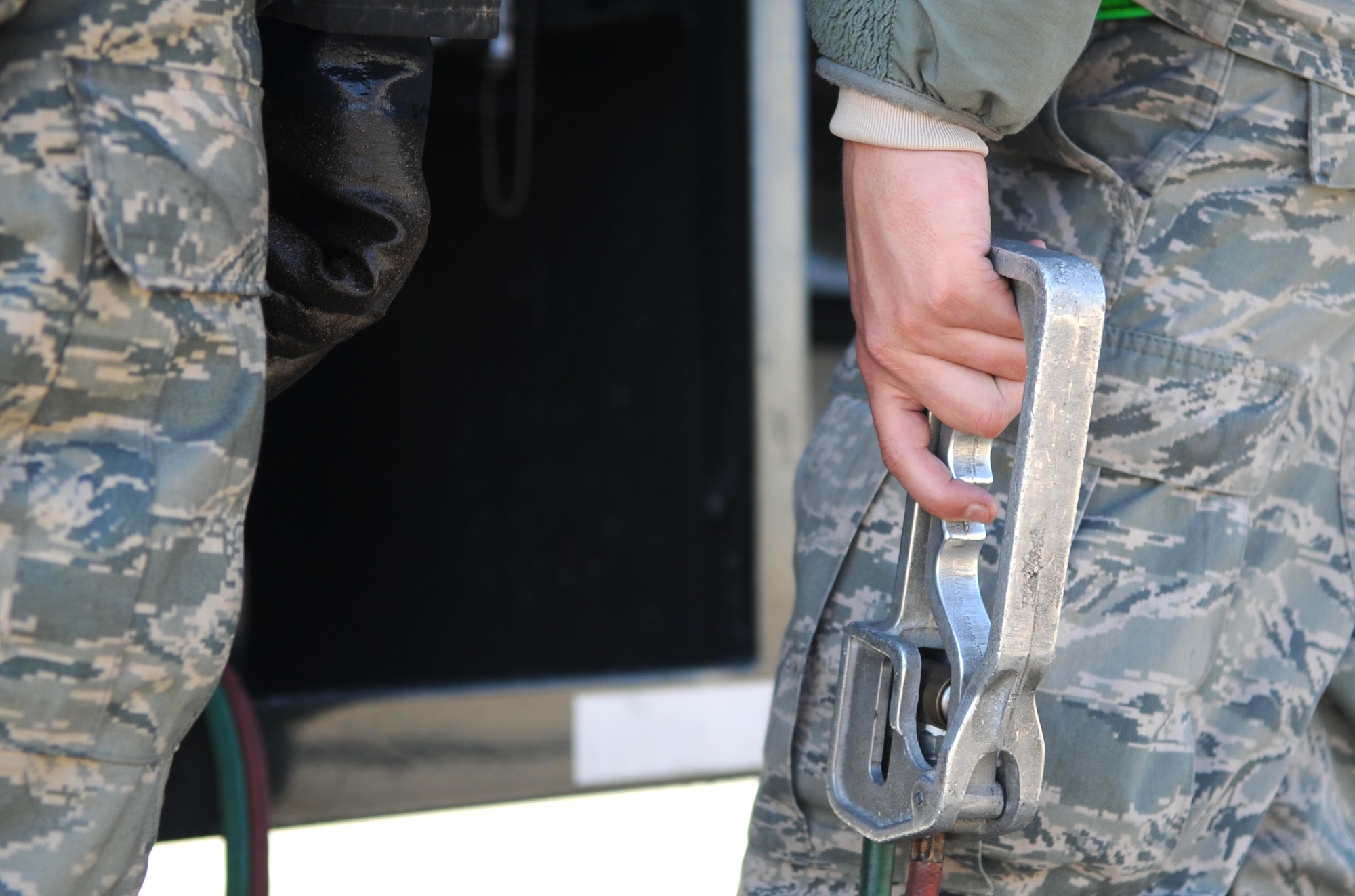 Senior Airman Mitchell Weger, 4th Logistics Readiness Squadron fuels distribution operator, grips the “dead man” handle while refueling an F-15E Strike Eagle at Seymour Johnson Air Force Base, North Carolina, Feb. 11, 2015. The “dead man” is a cutoff switch that must be held at all times during a refueling operation in case of an emergency. (U.S. Air Force photo/Senior Airman Ashley J. Thum)