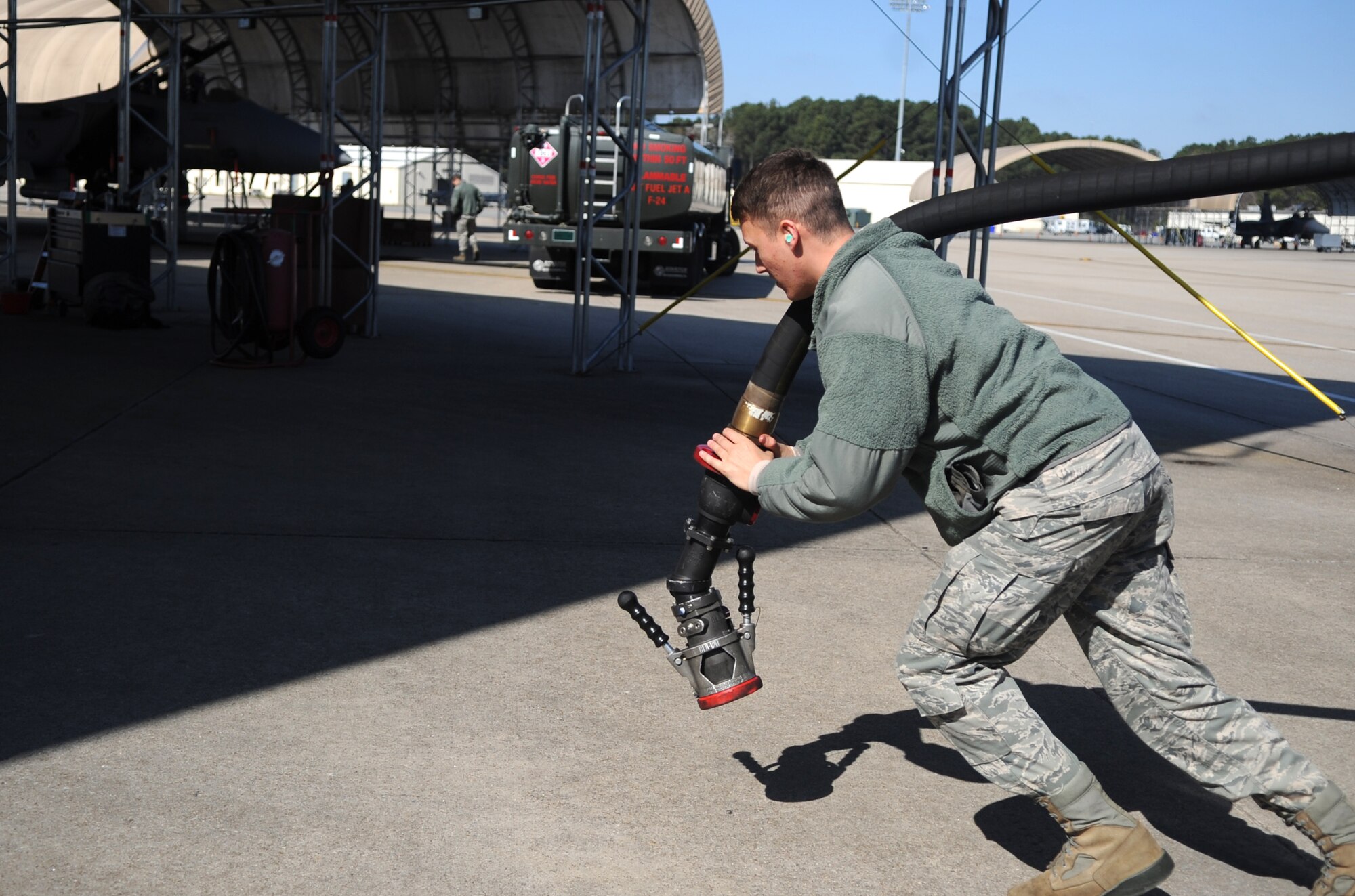 Senior Airman Mitchell Weger, 4th Logistics Readiness Squadron fuels distribution operator, carries a fuel hose to a waiting F-15E Strike Eagle at Seymour Johnson Air Force Base, North Carolina, Feb. 11, 2015. Each F-15E is equipped with two conformal fuel tanks with a capacity of 750 gallons each. (U.S. Air Force photo/Senior Airman Ashley J. Thum)
