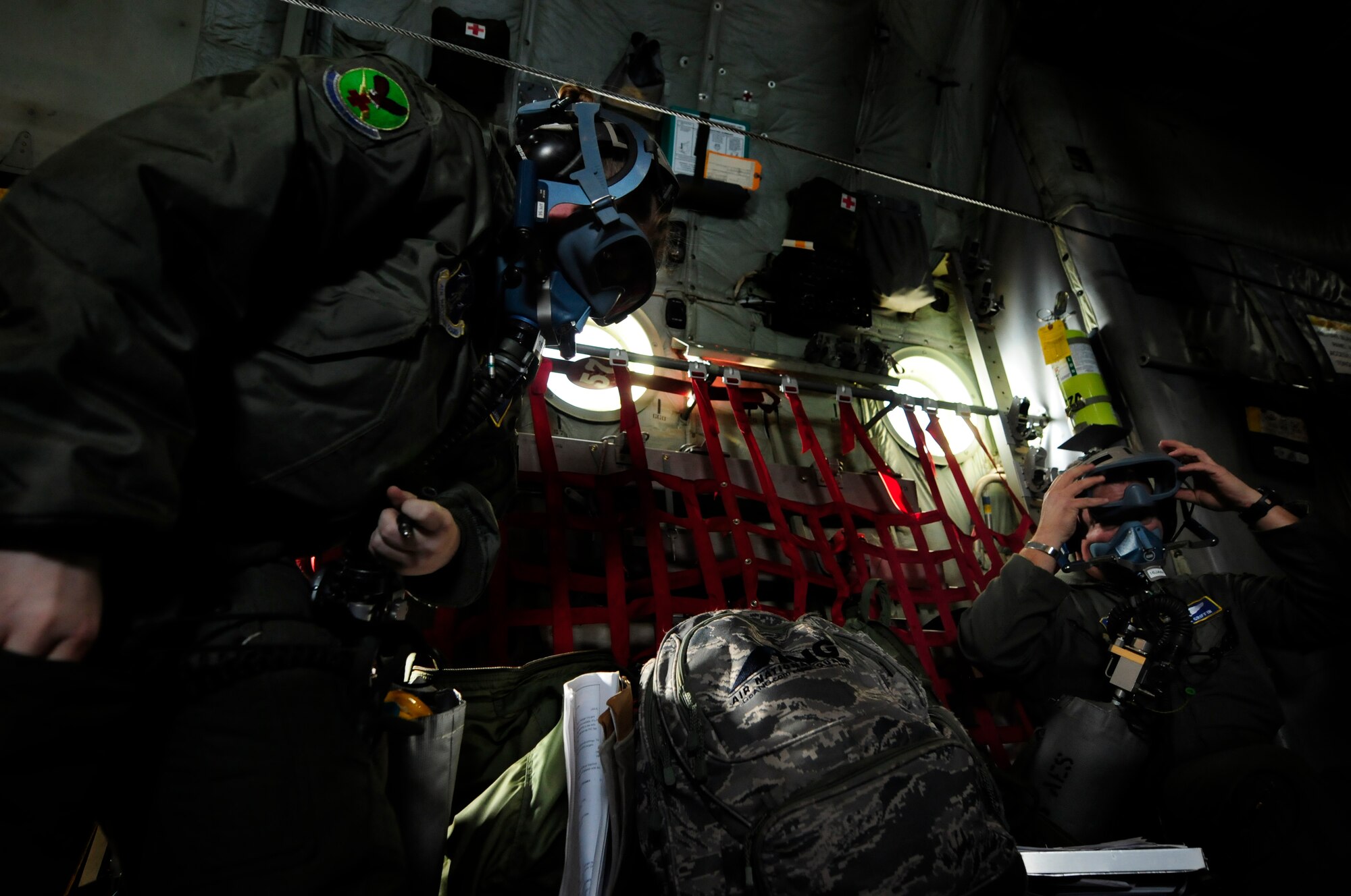 U.S. Air Force Senior Airman Brittany Callahan (left) and 1st Lt. Shawn Griffin (right) don oxygen masks as part of an emergency procedure during a scenario on an aeromedical training mission roundtrip from North Carolina Air National Guard Base, Charlotte Douglas Intl. Airport, Jan. 9, 2015. The training mission scenario is to transfer patients from Landstuhl Medical Center, Germany, to Malcolm Grove Medical Center, Md. (U.S. Air National Guard photo by Staff Sgt. Julianne M. Showalter, 145th Public Affairs/ Released)