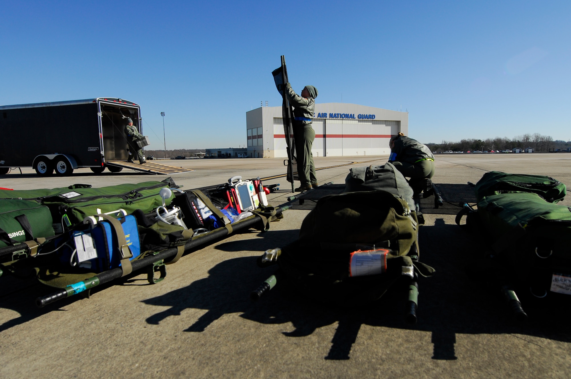 U.S. Air Force Joy-Lynn Bishop (center), 156th Aeromedical Evacuation Squadron, opens a litter for an aeromedical training mission at the North Carolina Air National Guard Base, Charlotte Douglas Intl. Airport, Jan. 9, 2015. The training mission scenario is to transfer patients from Landstuhl Medical Center, Germany, to Malcolm Grove Medical Center, Md. During this scenario Bishop will act as a simulated patient with severe obsessive compulsive disorder. (U.S. Air National Guard photo by Staff Sgt. Julianne M. Showalter, 145th Public Affairs/ Released)