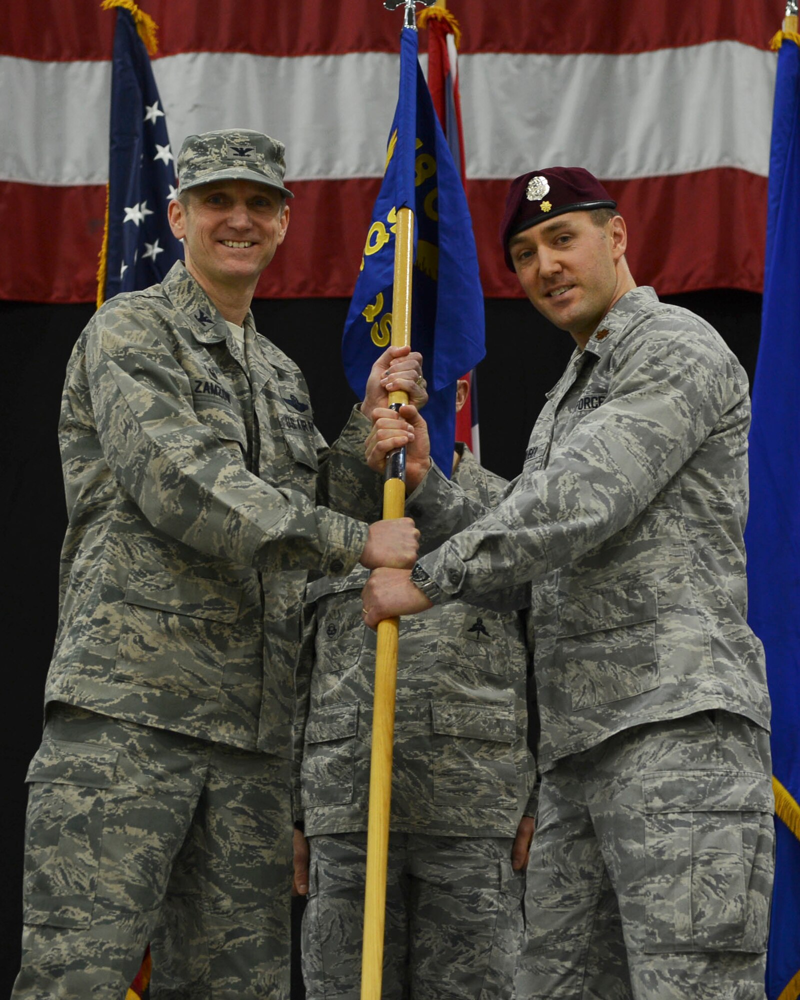 Col. Scottie Zamzow, 48th Operations Group commander, presents command of the 57th Rescue Squadron to Maj. Patrick Gruber at Royal Air Force Lakenheath, England, Feb. 18, 2015. The passing of the guidon is a representation of the unit’s command role. (U.S. Air Force photo by Airman 1st Class Dawn M. Weber/Released)