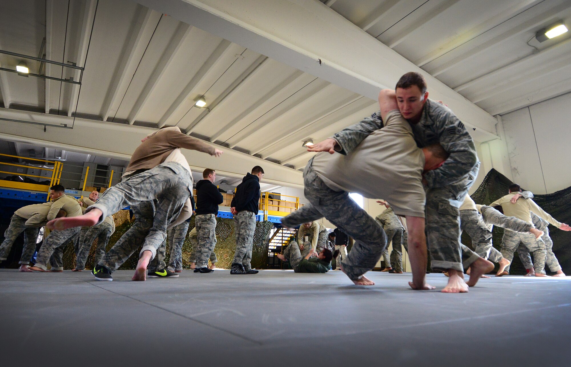 U.S. Air Force Senior Airman Justin Youngblood, 31st Security Forces Squadron member, tosses Senior Airman Joseph Struzik during a combative skills course, Feb. 18, 2015, at Aviano Air Base, Italy. Twenty 31 SFS Airmen were selected by their leadership to participate in the 50-hour course that will allow each member to take the training they learned and teach it to the rest of the squadron. (U.S. Air Force photo by Senior Airman Matthew Lotz/Released)