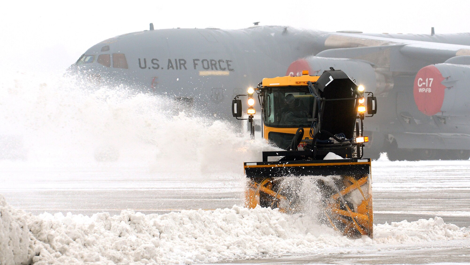 WRIGHT-PATTERSON AIR FORCE BASE, Ohio – Snow is removed around a 445th Airlift Wing C-17 Globemaster III as the temperature dips down to 1 below zero with a wind chill of nine below zero February 19, 2015. (U.S. Air Force photo/Tech. Sgt. Frank Oliver)
