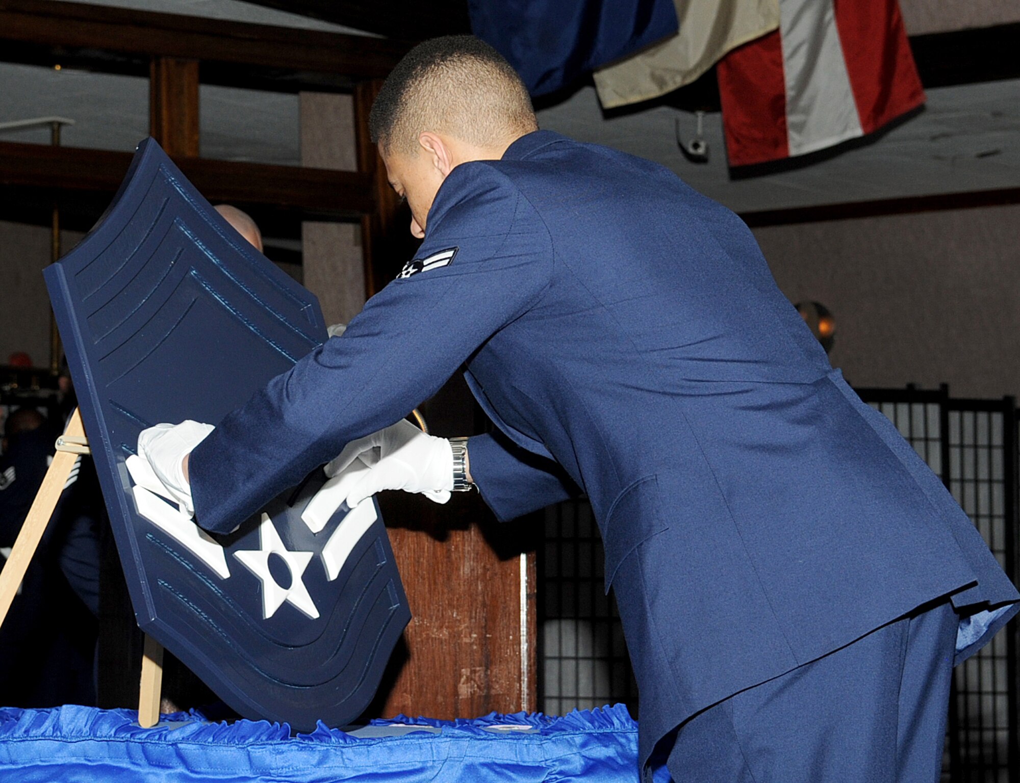 U.S. Air Force Airman 1st Class Daurice J. Beckwith, 18th Maintenance Group plans and scheduling specialist, places two pieces of wood representing the rank of airman first class on the ceremonial plaque at Kadena Air Base, Japan, Feb. 13, 2015. The building of the stripes is part of the chief’s ceremony explaining each rank they have achieved and their role in the Air Force at that rank. (U.S. Air Force photo by Airman 1st Class Zackary A. Henry)