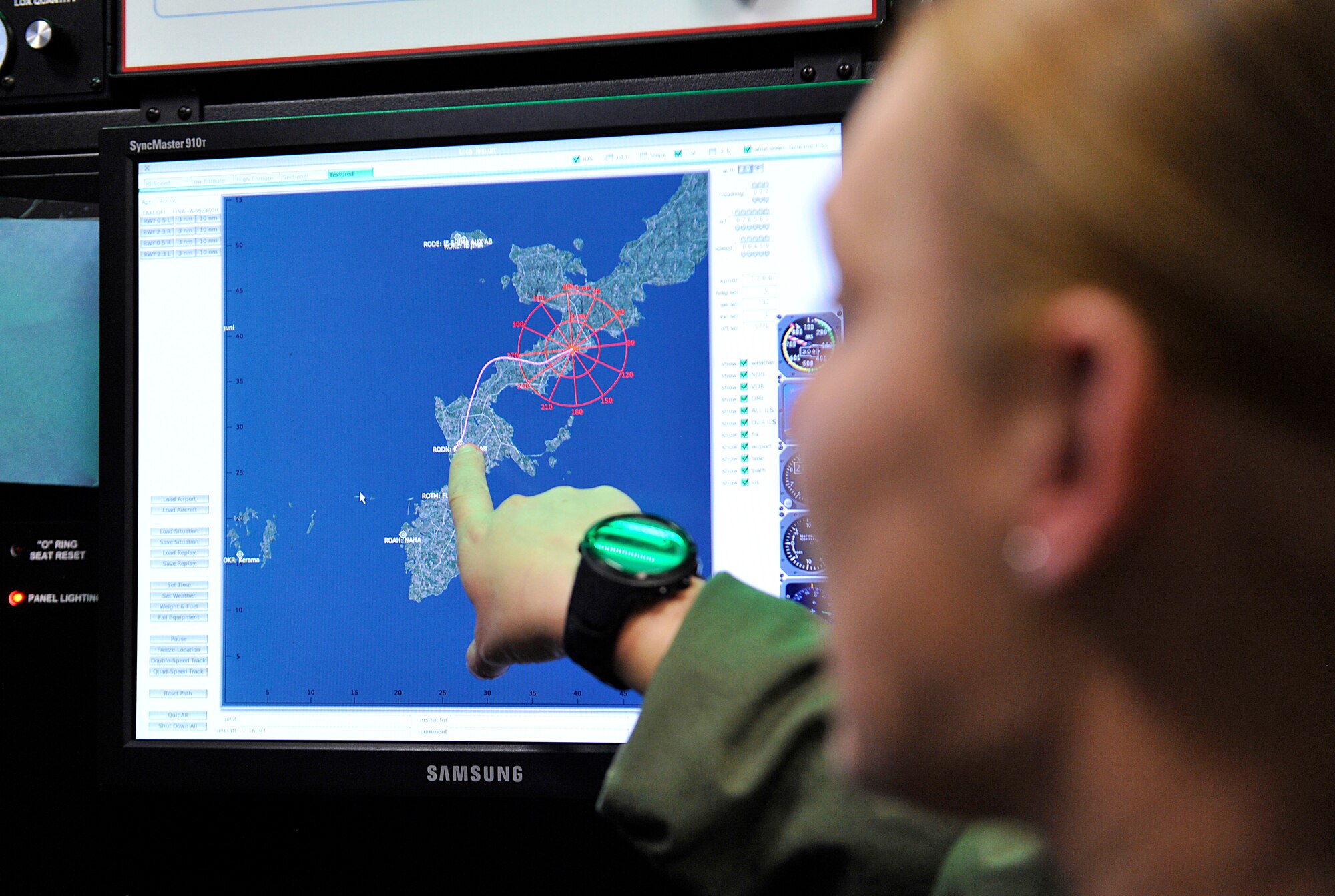 U.S. Air Force Tech. Sgt. Charrissa Smith, 18th Aerospace Medicine Squadron aerospace physiology technician, points to Kadena Air Base on the Hypoxia Familiarization operator screen during a Japan Air Self-Defense Force personnel visit for Reduced Oxygen Breathing on Kadena Air Base, Japan, Feb. 12, 2015. Five JASDF personnel visited the Aerospace and Operational Physiology team to observe how the U.S. Air Force use the Reduced Oxygen Breathing Device for hypoxia training, which the JASDF will begin using in the near future. (U.S. Air Force photo by Naoto Anazawa)