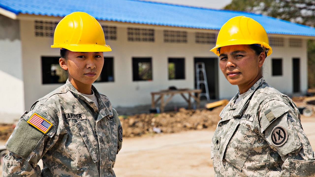Army Sgt. Noryann Larimer, left, and Army Spc. El Jessica Joi Balajadia, carpentry and masonry specialists with the 797th Engineer Company (Vertical) based out of the U.S. Army Reserve Center in Barrigada, Guam, pose in front a newly raised building at Ban Nhong-Plong Elementary School located in Chai Badan District, Lop Buri Province, Thailand, Feb. 10, 2015. As part of Exercise Cobra Gold 2015, a multinational force of Royal Thai Armed Forces, People’s Liberation Army of China and U.S. Army engineers, Larimer and Balajadia have been constructing a new, multipurpose school facility in Ban Nhong-Plong. Larimer and Balajadia are the only female constructors on the project and are natives of Maite and Yona, Guam, respectively. U.S. Marine Corps Photo by Cpl. James Marchetti