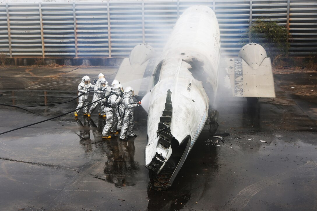 U.S. Marines and Royal Thai Navy firefighters douse a fire inside the shell of an old airplane during a fire response scenario for exercise Cobra Gold 2015 on Utapao Royal Thai Navy Airfield, Kingdom of Thailand, Feb. 18, 2015. Exercise Cobra Gold is an annual exercise designed to increase cooperation, interoperability and collaboration among partner nations in order to achieve effective solutions to common challenges. 