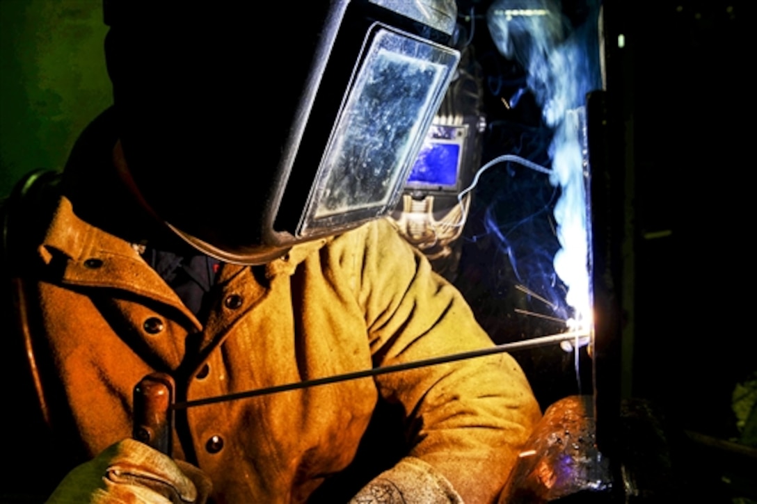 Navy Petty Officer 2nd Class Gavin Templeton practices welding on a steel plate aboard the USS John C. Stennis in Bremerton, Wash., Feb. 17, 2015. The Stennis is training to prepare for future deployments. Templeton is a hull maintenance technician. 