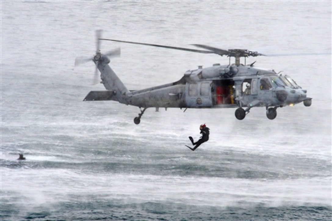 Search and rescue swimmers assigned to Helicopter Sea Combat Squadron 4 train from an MH-60S Seahawk helicopter during qualifications in San Diego, Jan. 28, 2015.  