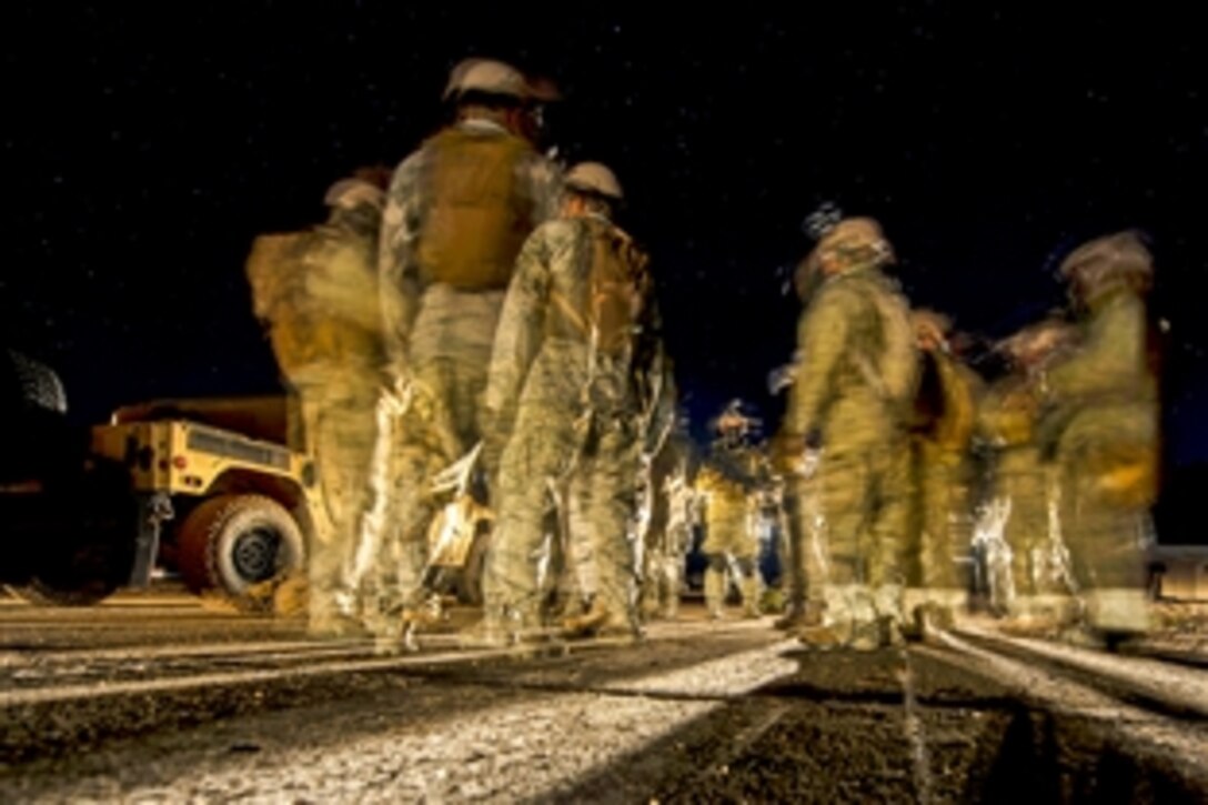 Airmen prepare for a night patrol while participating in survival training during exercise Scorpion Lens 15 on North Auxiliary Airfield in North, S.C., Feb., 11, 2015. The airmen are assigned to the 1st Combat Camera Squadron on Joint Base Charleston, S.C.