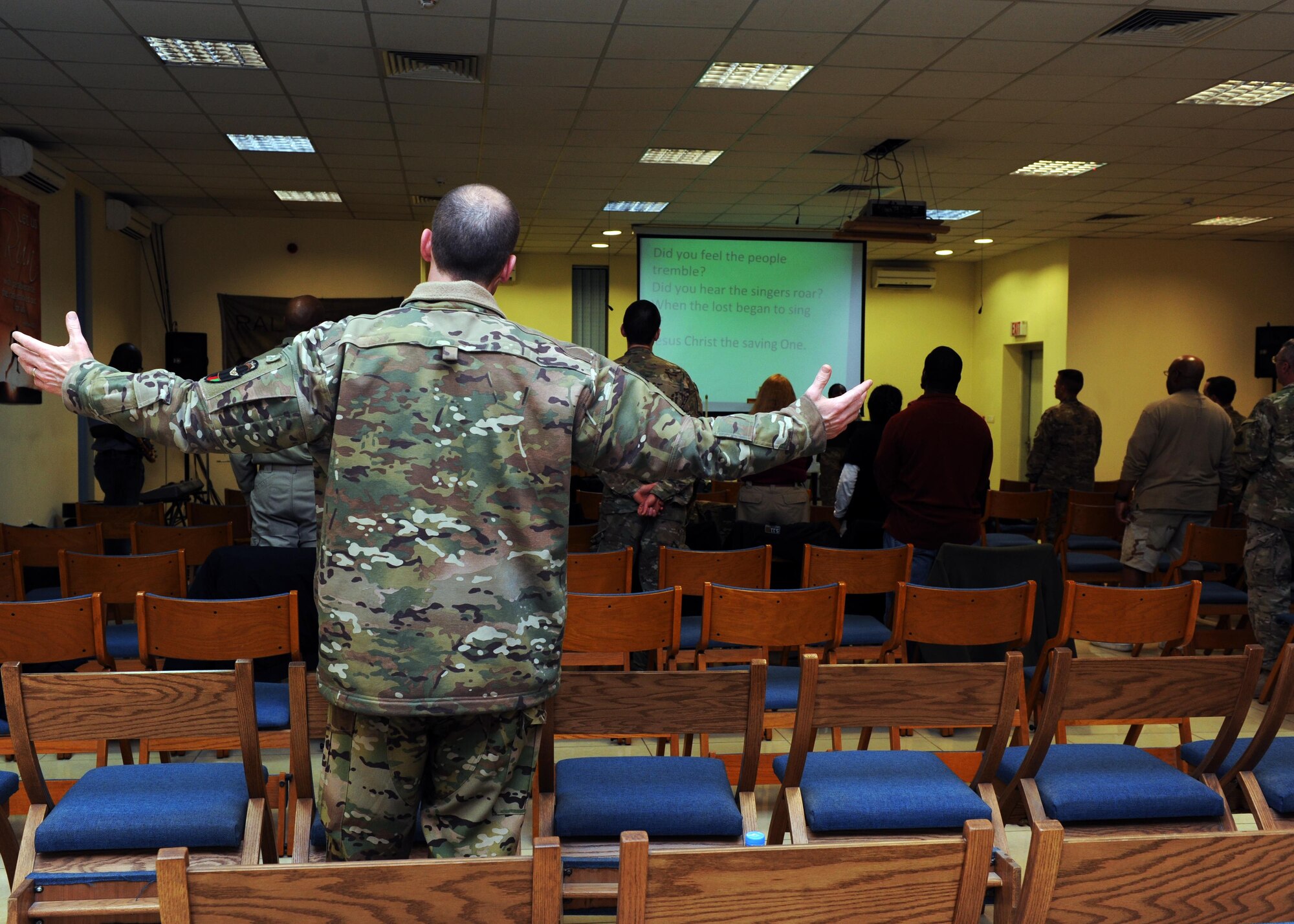 A U.S. Air Force Airman raises his hands during the praise and worship portion of an evening church service conducted by U.S. Air Force Maj. William Braswell, 455th Air Expeditionary Wing chaplain, Feb. 15, 2015 at Hamid Karzai International Airport in Kabul. Braswell, accompanied by U.S. Air Force Tech. Sgt. Aleric Hebert, 455 AEW chaplain assistant, travels throughout the U.S. Air Force Central Command Area of Responsibility engaging with Airmen and conducting church services to ensure deployed servicemembers are spiritually fit to fight.(U.S. Air Force photo by Staff Sgt. Whitney Amstutz/released)