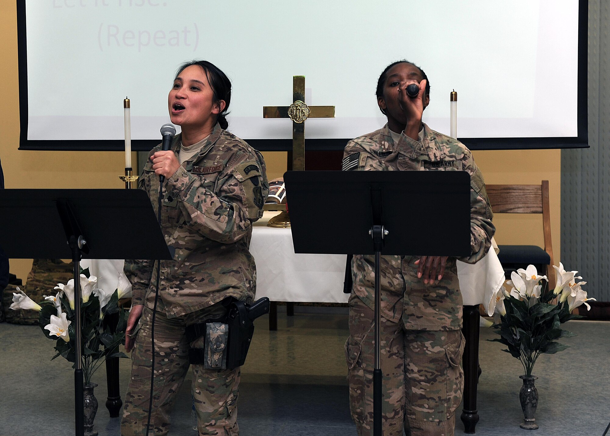 U.S. servicemembers sing during the praise and worship portion of an evening church service conducted by U.S. Air Force Maj. William Braswell, 455th Air Expeditionary Wing chaplain, Feb. 15, 2015 at Hamid Karzai International Airport in Kabul. Braswell, accompanied by U.S. Air Force Tech. Sgt. Aleric Hebert, 455 AEW chaplain assistant, travels throughout the U.S. Air Force Central Command Area of Responsibility engaging with Airmen and conducting church services to ensure deployed servicemembers are spiritually fit to fight.(U.S. Air Force photo by Staff Sgt. Whitney Amstutz/released)