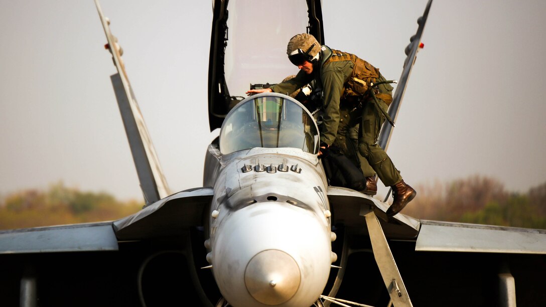 A U.S. Marine pilot enters the cockpit of an F/A-18 Hornet, Feb. 16.  U.S. Marines attached to Marine Aircraft Group 12, 1st Marine Aircraft Wing, III Marine Expeditionary Force, and the Royal Thai Air Force train together to maintain readiness and interoperability in support of peace and security in the region as part of Exercise Cobra Gold 2015. Exercise Cobra Gold 2015 has provided an opportunity for U.S. Marines and the Royal Thai Air Force to train together.