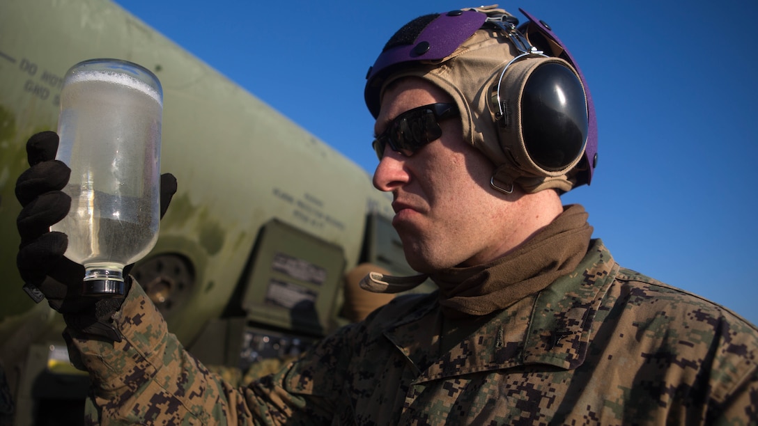 Lance Cpl. Tyler Sheeley, a bulk fuel specialist with Marine Wing Support Squadron 272, examines a fuel sample while preparing for a forward arming and refueling point in Engelhard, N.C., Feb. 12, 2015. The squadron’s FARP exercise is designed to get the Marines to refuel landed helicopters as quickly as possible, so the aircrafts can quickly take off after filling up. 