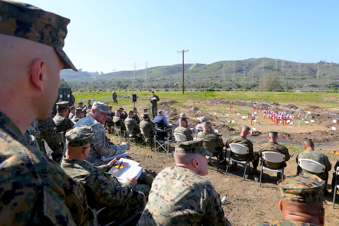 Service members listen to a I Marine Expeditionary Force subordinate command element representative delivers a brief during a rehearsal of concept drill on its role in I Marine Expeditionary Force Exercise 2015 aboard Marine Corps Base Camp Pendleton, Calif., Feb. 17.  MEFEX 15 will allow I MEF to exercise and evaluate its current readiness to support operations around the world.
