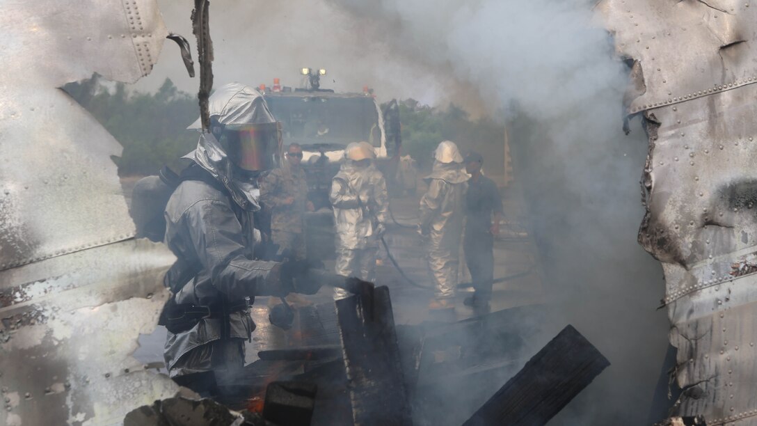 Cpl. Justin Groom, a U.S. Marine aircraft rescue firefighter with Marine Wing Support Squadron 172, 1st Marine Aircraft Wing, stokes the fire inside of a scrap airplane during a fire response scenario Feb 18, at Utapao Royal Thai Navy Airfield, Kingdom of Thailand. The scenario was for exercise Cobra Gold 2015, an annual exercise designed to improve international relationships and improve security within the region. 