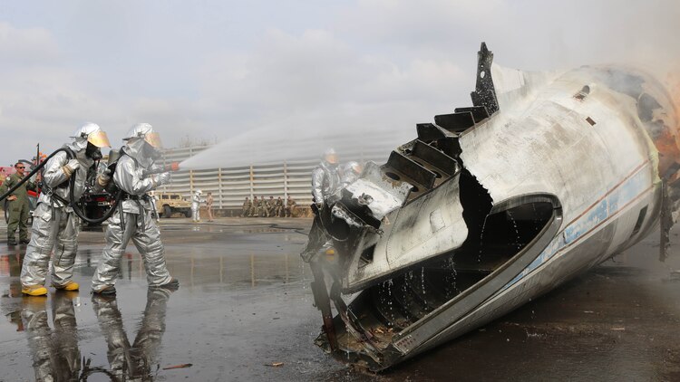 U.S. Marines and Royal Thai Navy firefighters spray the body of a burning airplane fuselage to practice containing the flame during a fire response scenario Feb. 18, 2015 at Utapao Royal Thai Navy Airfield, Kingdom of Thailand. The scenario was for exercise Cobra Gold 2015, an annual exercise designed to improve international relationships and improve security within the region. 