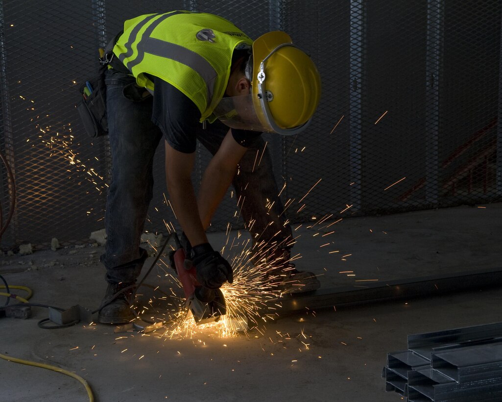 A worker stands amid a burst of sparks as he cuts steel wall posts July 2014. The U.S. Army Corps of Engineers Sacramento District’s contractor, Big D Construction of Salt Lake City, is the prime contractor to construct the annex to the life sciences test facility at Dugway Proving Ground, Utah. (Cropped for emphasis)