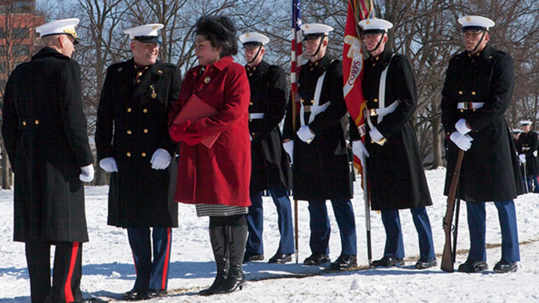 Gen. Joseph Dunford, commandant of the Marine Corps, thanks Susan Barrett, wife of the outgoing Sergeant Major of the Marine Corps Micheal Barrett, for her sacrifice and devotion during her husband's service in the Marine Corps at the Marine Corps War Memorial in Arlington, Virginia, Feb. 20, 2015. Barrett retired from the Marine Corps after serving as active duty since 1981.