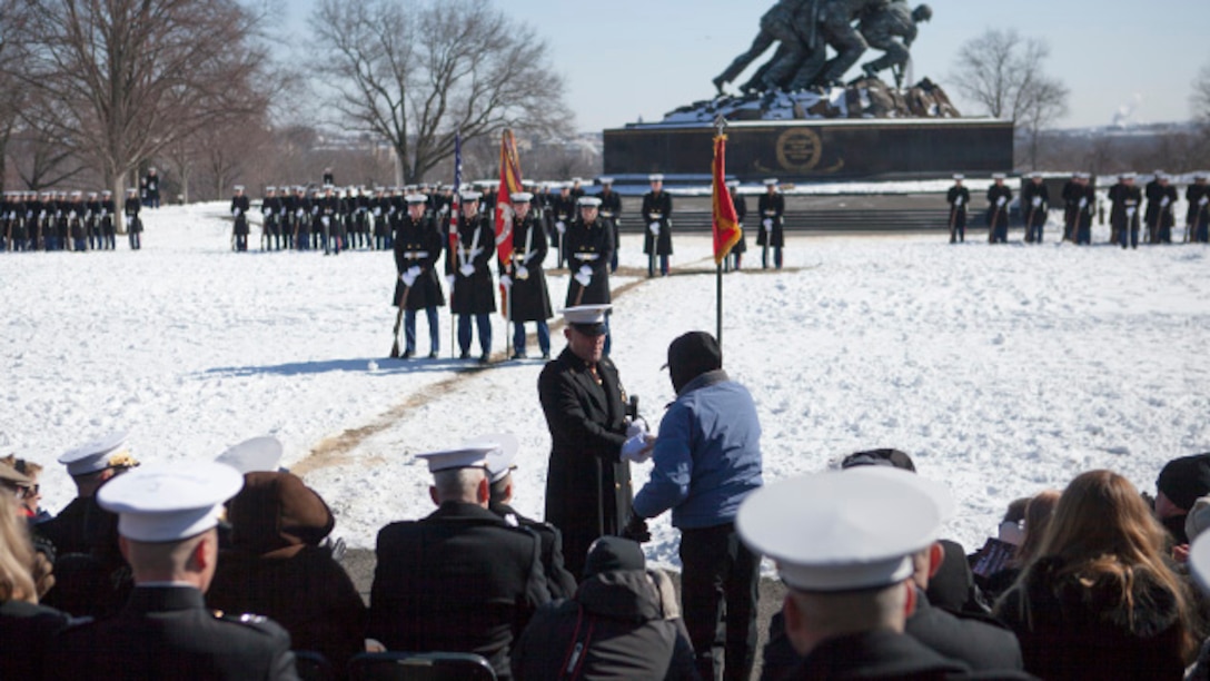 Sergeant Major Micheal Barrett, the 17th sergeant major of the Marine Corps, shakes the hand of his recruiter, during the sergeant major of the Marine Corps post and relief ceremony at the Marine Corps War Memorial, Arlington, Virginia, Feb. 20, 2015. Barrett has served in the Marine Corps since 1981.