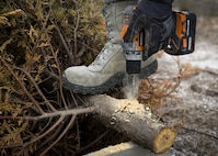 Senior Airman Raul Pedroza, 1st Special Operations Civil Engineer Squadron structural apprentice, drills through the base of a Christmas tree at Hurlburt Field, Fla., Feb. 3, 2015. To preserve natural resources on Hurlburt, the recycled Christmas trees create a place for fish to gather, forage and avoid predation from larger fish in Gator Lake. (U.S. Air Force photo by Senior Airman Meagan Schutter/Released)