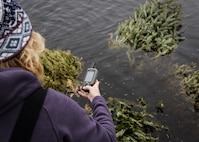 Kristi Walsh, 1st Special Operations Civil Engineer Squadron natural and cultural resource manager, annotates the placement of the recycled Christmas trees in Gator Lake at Hurlburt Field, Fla., Feb. 3, 2015. The trees are providing a suitable habitat for marine life. (U.S. Air Force photo by Senior Airman Meagan Schutter/Released)