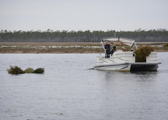 The 1st Special Operations Civil Engineer Squadron drops recycled Christmas trees into Gator Lake on Hurlburt Field, Fla., Feb. 3, 2015. Brush piles, such as Christmas trees, can provide a place for fish to gather, forage and avoid predation from larger fish. (U.S. Air Force photo by Senior Airman Meagan Schutter/Released)