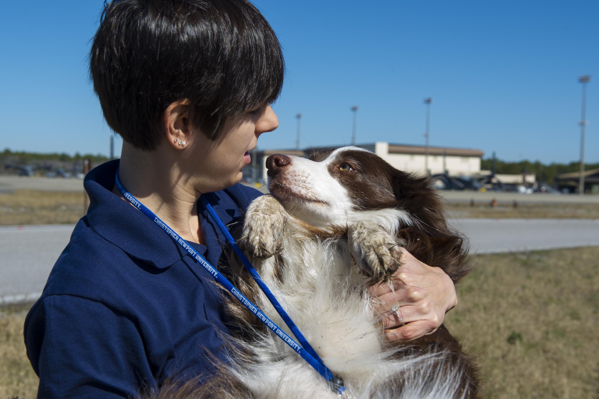 Ambre Depopolo, 1st Special Operations Wing Safety Office wildlife manager and ecologist, cradles Sonic, a Bird and Wildlife Aircraft Strike Hazard canine, after removing a burr from her paw on the flightline on Hurlburt Field, Fla., Jan. 26, 2015. Depopolo works to avoid bird strikes not only to protect Hurlburt Field’s resources, but also the local animals. (U.S. Air Force photo/Senior Airman Hayden K. Hyatt)