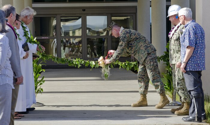 Col. Eric W. Schaefer (center), commanding officer of Marine Corps Base Hawaii, unties the maile lei as Navy Capt. George Suther, executive officer of Naval Facilities Engineering Command Hawaii (right) and Kahu Solomon Borabora look on during the dedication ceremony of the Marine Corps Air Station Kaneohe Bay Operations and Aircraft Rescue and Firefighting Complex, Feb. 12, 2015. (U.S. Marine Corps photo by Kristen Wong/Released)