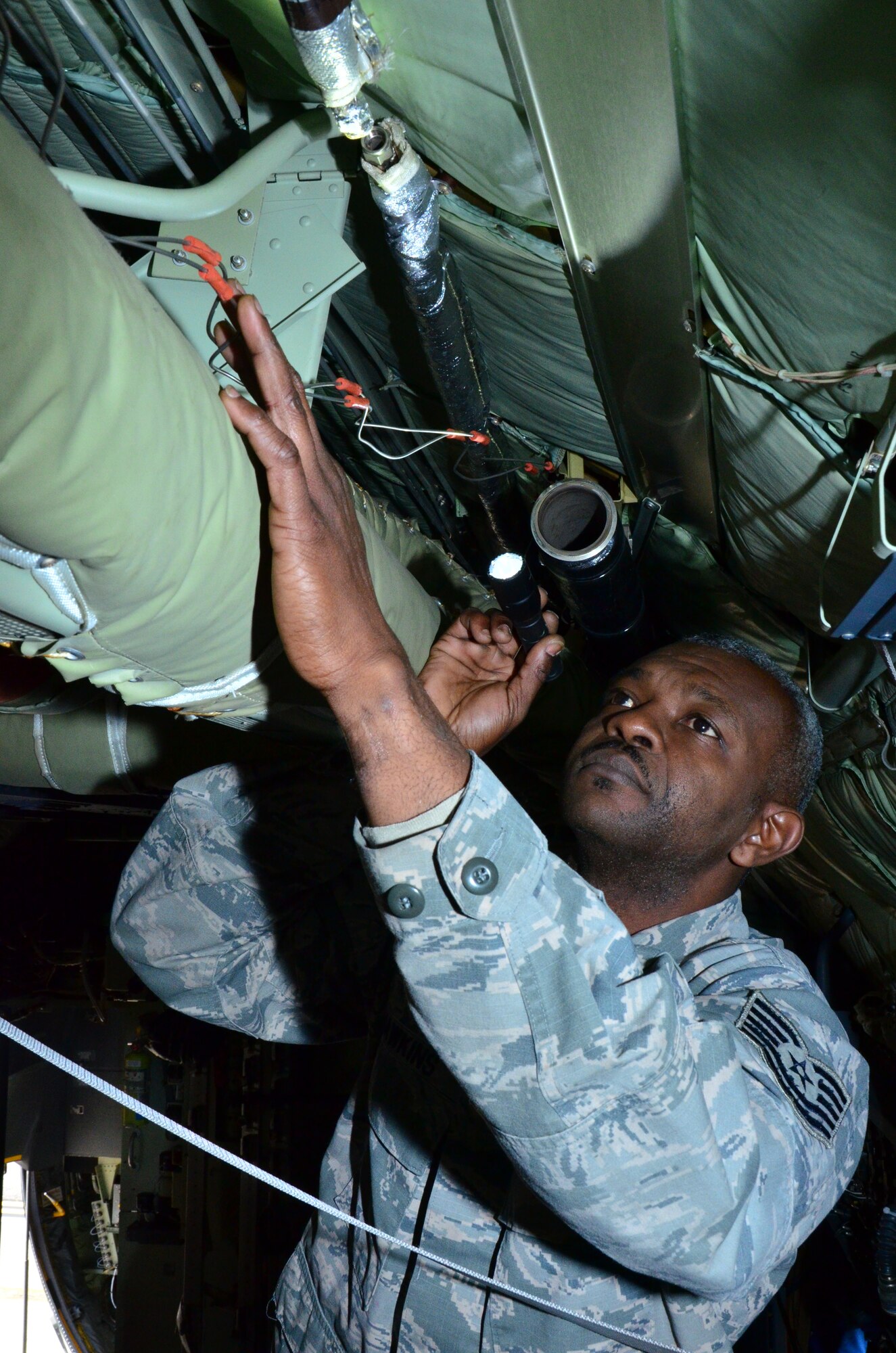 Tech Sgt. Vincent Hawkins, a crew chief with the 403rd Aircraft Maintenance Squadron inspects the affected area of a C-130J aircraft at Keesler Air Force Base, 10 Feb.
