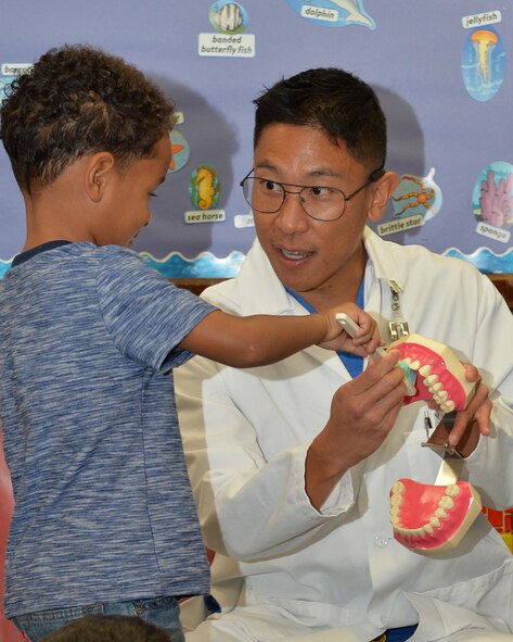 Capt. Evan Masunaga, 15th Aerospace Medicine Squadron demonstrates proper oral hygiene to a student at the Main Child Development Center on Joint Base Pearl Harbor-Hickam, Hawaii, Feb. 19, 2015. Every February the dental flight visits local elementary students providing oral hygiene tips. This year the 15th AMDS will visit four elementary schools and two child development centers on JBPHH to deliver toothbrushes and instruct to more than 1,200 local youth on oral hygiene. (U.S. Air Force photo by Tech. Sgt. Aaron Oelrich/Released) 