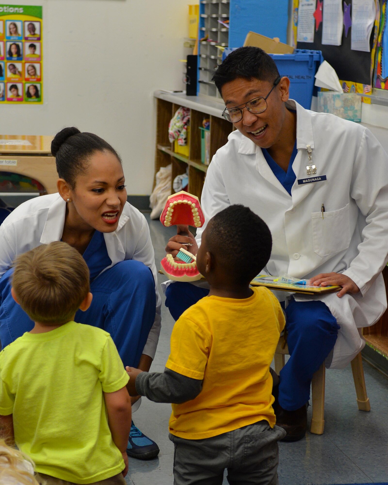 Staff Sgt. Britney Jones (Left) and Capt. Evan Masunaga both from the 15th Aerospace Medicine Squadron demonstrates proper oral hygiene to students at the Main Child Development Center on Joint Base Pearl Harbor-Hickam, Hawaii, Feb. 19, 2015. In honor of National Children's Dental Health Month, every February the 15th AMDS visit local elementary students to provide oral hygiene education. (U.S. Air Force photo by Tech. Sgt. Aaron Oelrich/Released) 