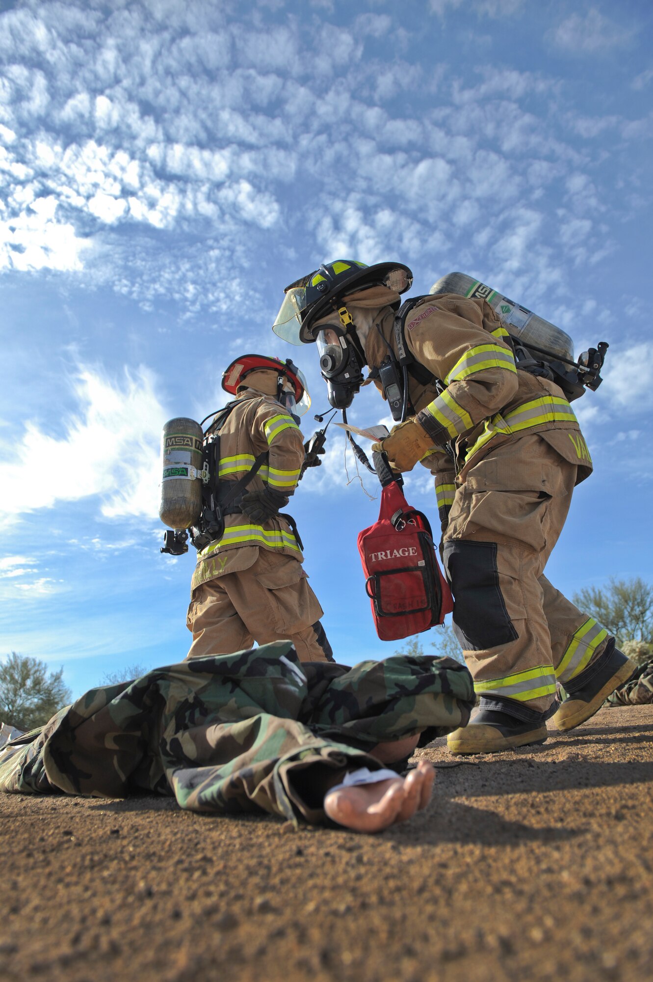 U.S. Air Force Senior Airman Elson Valencia and Capt. Michael Reilly, 355th Civil Engineering Squadron firefighters, triage a simulated victim during a downed aircraft exercise at Davis-Monthan Air Force Base, Ariz., Feb. 19, 2015. D-M was evaluated by the Inspector General’s office to ensure the agencies’ response was effective and timely. (U.S. Air Force photo by Airman 1st Class Chris Drzazgowski/Released)