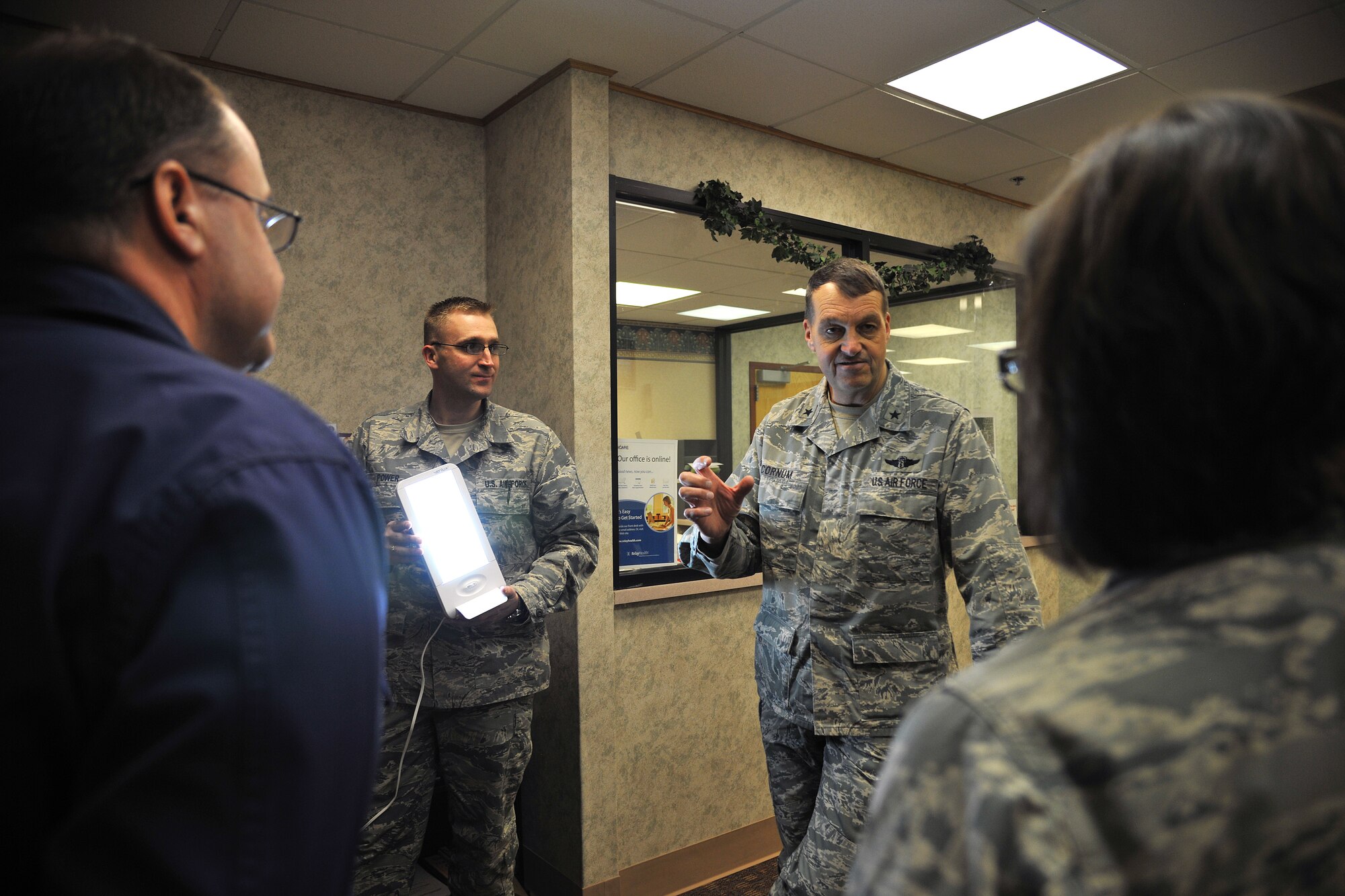 Brig. Gen. (Dr.) Kory Cornum, Air Mobility Command Surgeon, asks questions concerning the number of Airmen allowed to check out light boxes for Seasonal Affective Disorder (SAD) on Feb. 19, 2015 at the Mental Health Clinic on Grand Forks Air Force Base, N.D. SAD is a type of depression that can occur during the fall and winter months. The light boxes mimic outdoor light and causes a chemical change in the brain that eases the symptoms of SAD. (U.S. Air Force photo/Senior Airman Xavier Navarro)