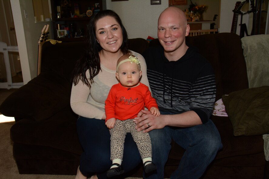 Christa Johnson (Left), the wife of Staff Sgt. Richard L. Johnson (Right), 660th Aircraft Maintenance Squadron KC-10 crew chief, sit with their daughter Ayda Johnson, inside their home Feb. 13, 2014. Richard was is now cancer free after a seventh month battle with the disease. He said he feels blessed to be cancer free and he’s looking forward to getting back to work. (U.S. Air Force photo/Tech. Sgt. James M. Hodgman)