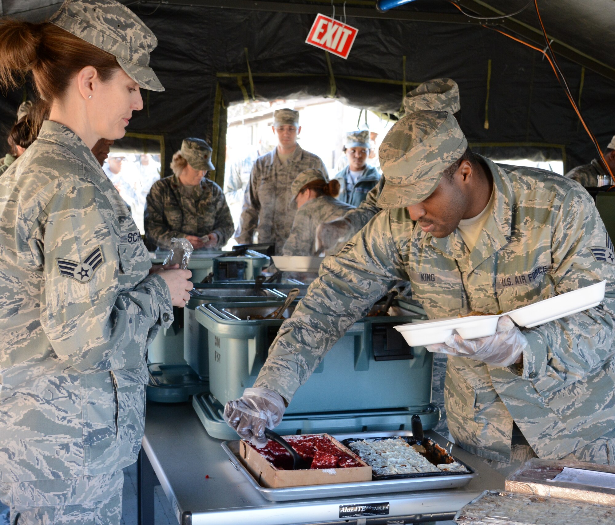 NAVAL AIR STATION FORT WORTH JOINT RESERVE BASE, Texas - Senior Airman Lamar King, 301st Services Flight food operations apprentice, serves Senior Airman Samantha Schneider, 301st Medical Group aerospace medical service apprentice, black forest cake for dessert Feb. 7 during the Air Force Reserve Command's 2015 Hennessy Competition here. While competing for their second Hennessy trophy, the 10-person team formed a single pallet expeditionary kitchen (SPEK) then served 165 Airmen lunch. (U.S. Air Force photo by Staff Sgt. Samantha Mathison)