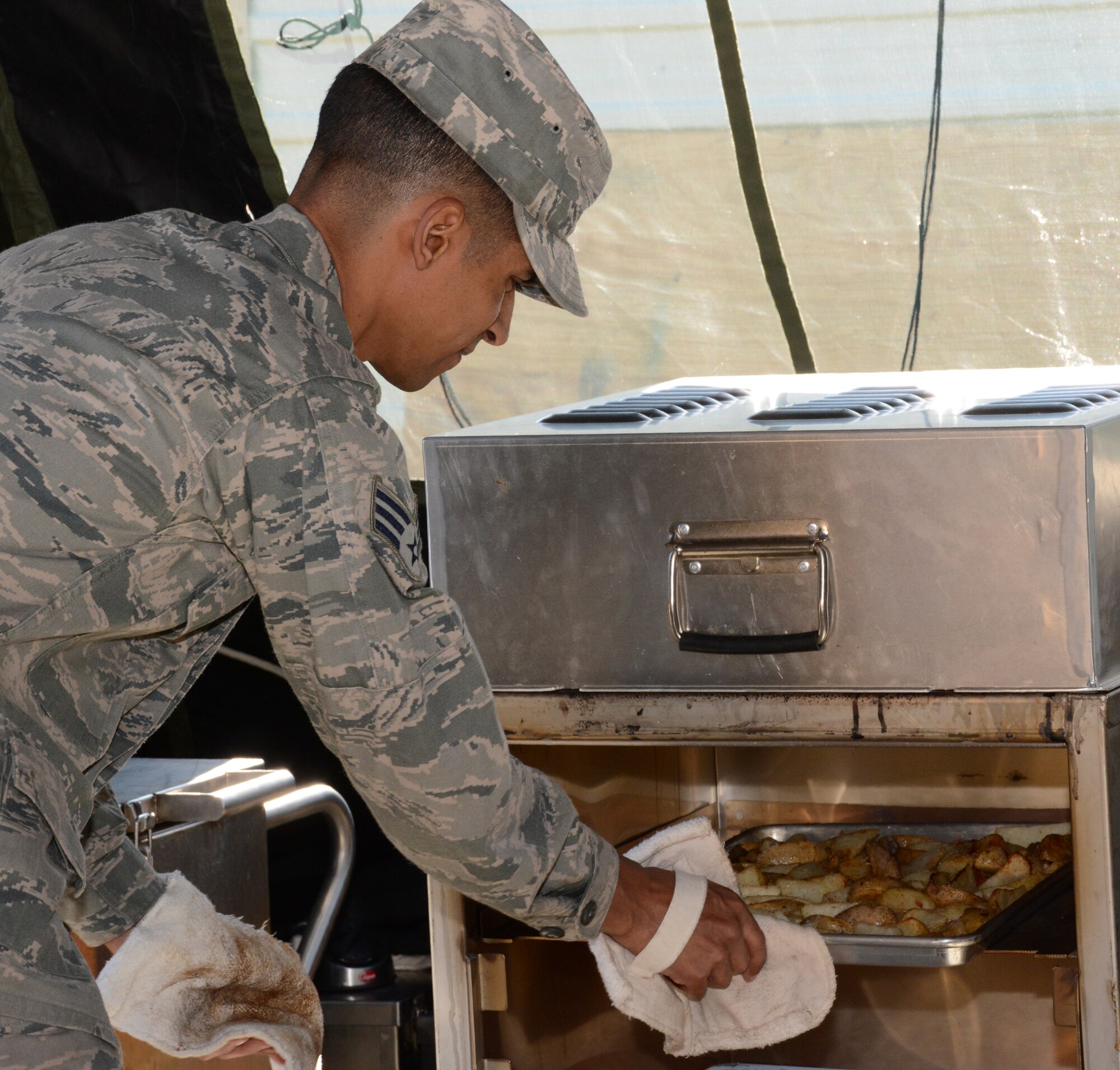 NAVAL AIR STATION FORT WORTH JOINT RESERVE BASE, Texas - Senior Airman Angel Agosto, 301st Services Flight food operations journeyman, checks the potato fries Feb. 7 during the food prep portion of the 2015 Air Force Reserve Command’s Hennessy competition here. While competing for their second consecutive trophy, the 10-person team formed a single pallet expeditionary kitchen (SPEK) then served 165 Airmen lunch. (U.S. Air Force photo by Staff Sgt. Samantha Mathison)