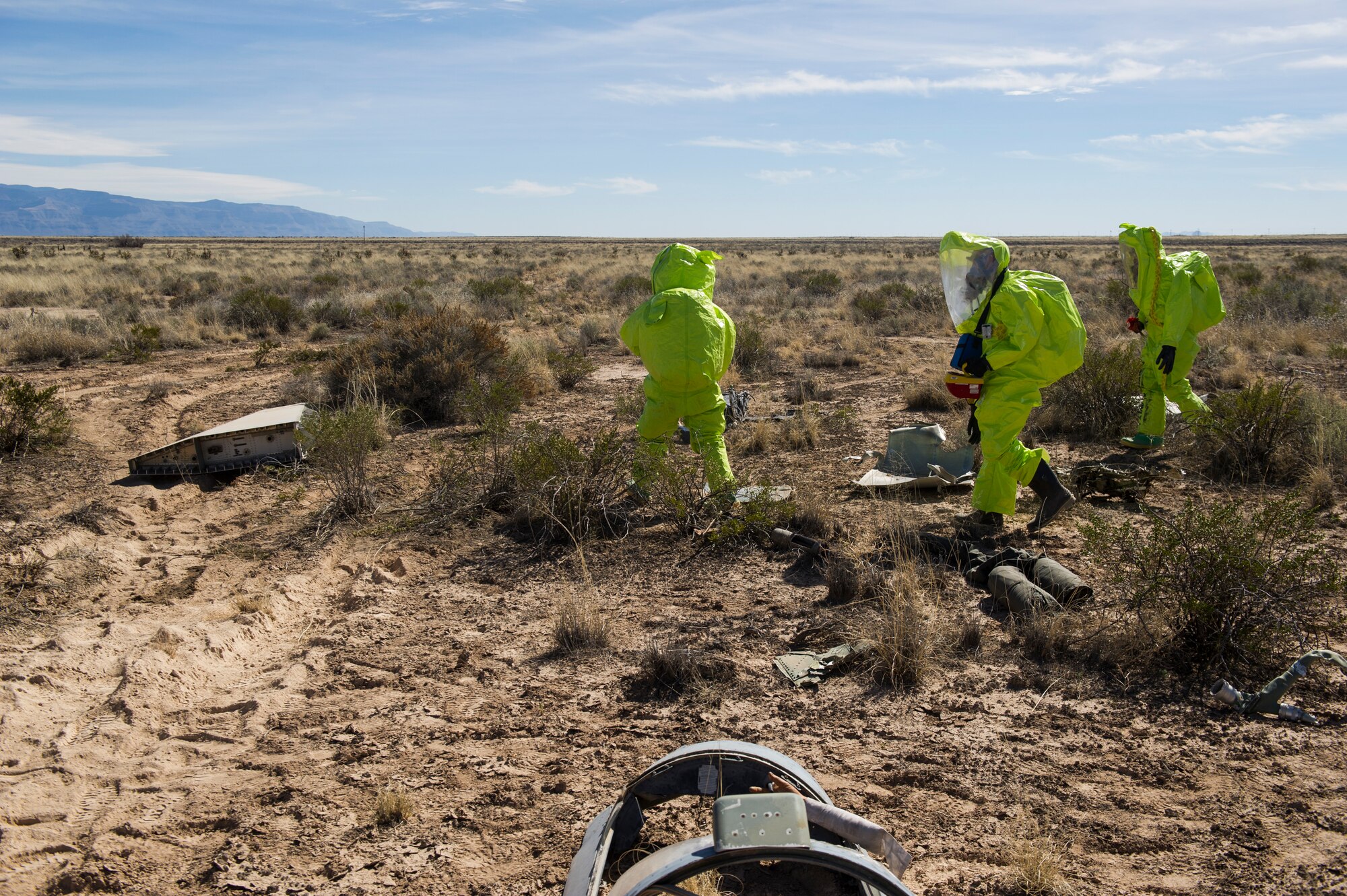 Members from the 49th Explosive Ordnance Disposal and Fuels Management flights survey a simulated aircraft accident during a Massive Accident Recovery Exercise at Holloman Air Force Base, N.M., Feb. 19. Airmen from EOD and Fuels flights enter the crash scene to identify any possible dangerous chemicals or explosives that may be present so the area can be secured for other responders to safely enter. (U.S. Air Force photo by Airman 1st Class Aaron Montoya / Released)