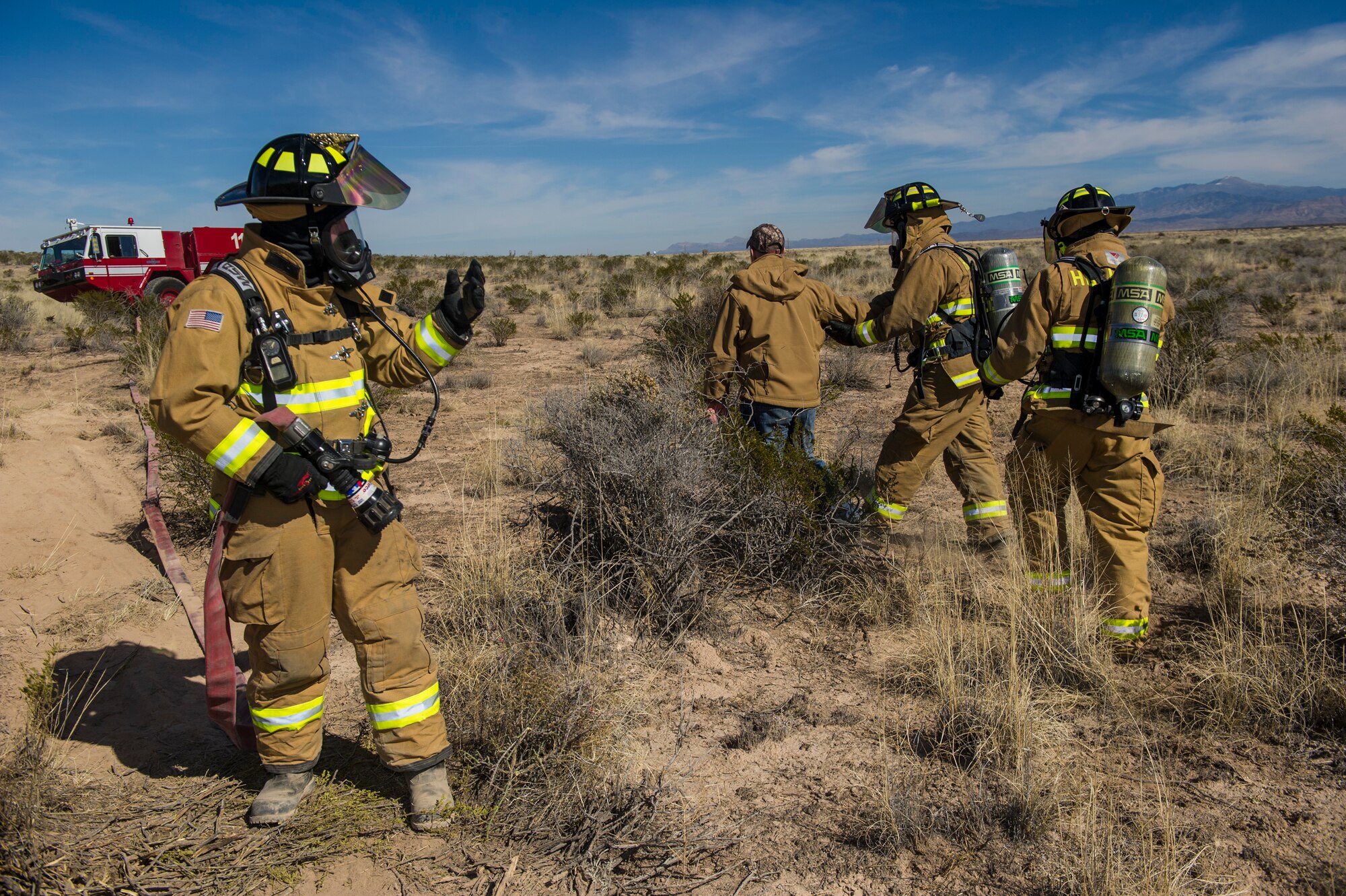Firefighters from the 49th Fire Protection Flight remove a bystander from a simulated aircraft crash scene during a Massive Accident Recovery Exercise at Holloman Air Force Base, N.M., Feb. 19. Holloman’s first responders participated in a MARE which allows them to practice responding to such incidents so real world accidents can be dealt with quickly and efficiently. (U.S. Air Force photo by Airman 1st Class Aaron Montoya / Released)