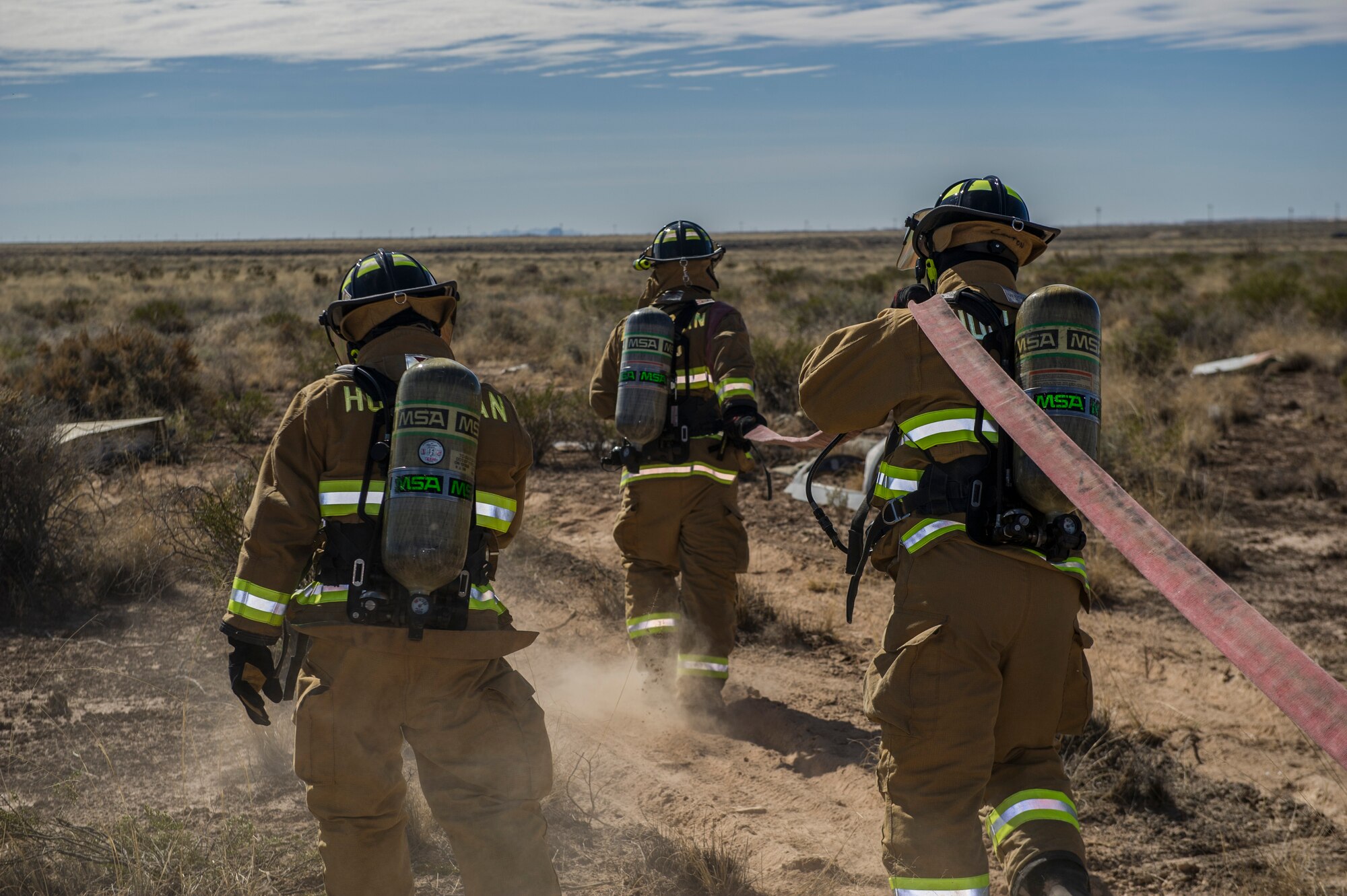Firefighters from the 49th Fire Protection Flight prepare to control a simulated aircraft accident site during a Massive Accident Recovery Exercise at Holloman Air Force Base, N.M., Feb. 19. Firefighters simulated taking control of flames from a burning aircraft while securing the scene for other first responders to safely enter. (U.S. Air Force photo by Airman 1st Class Aaron Montoya / Released)