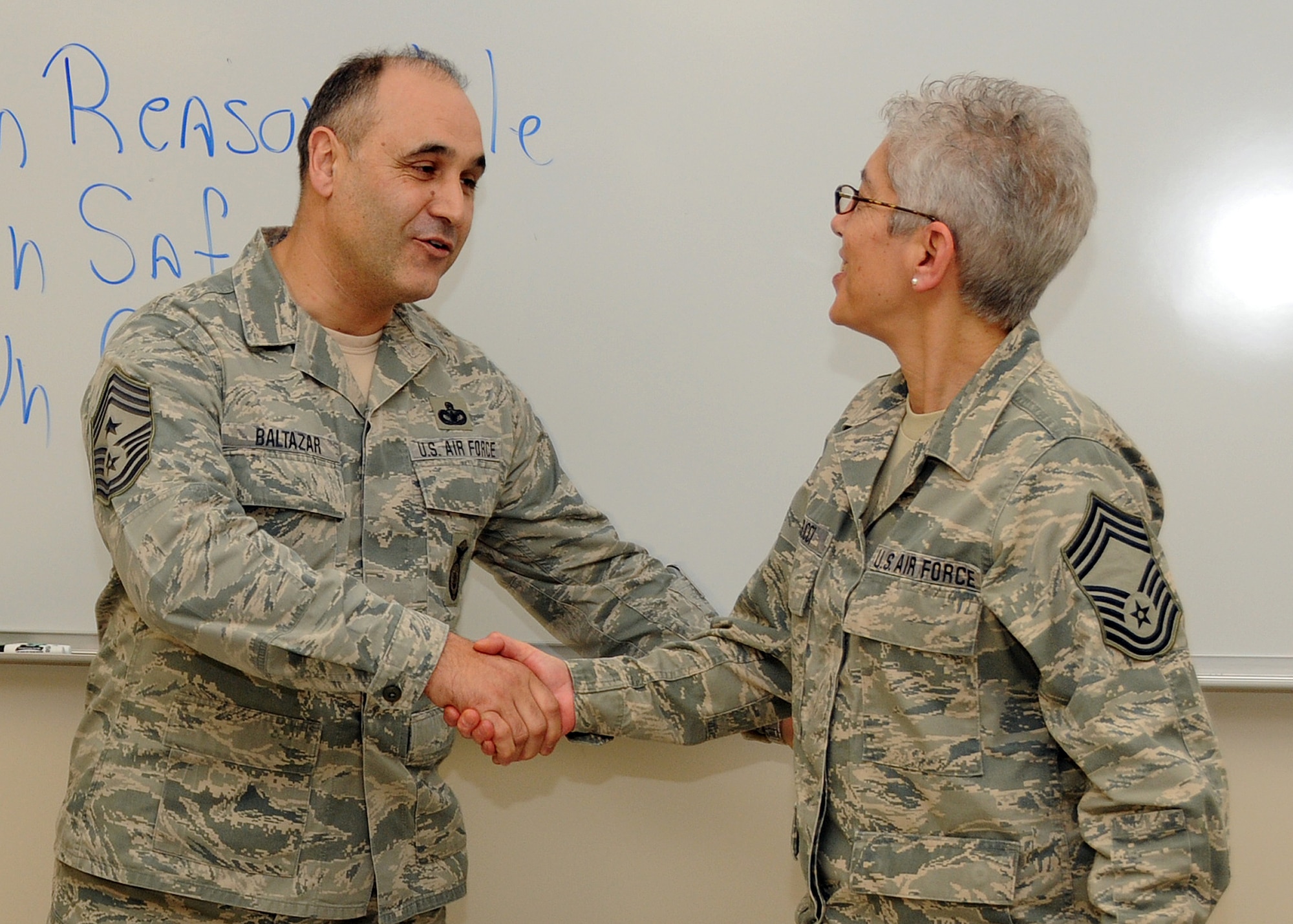 Command Chief Master Sergeant Jose Baltazar, Command Chief, 143d Airlift Wing, Rhode Island Air National Guard, presents Chief Master Sergeant Lorraine Casucci, Military Personnel Management Officer, RIANG, with a challenge coin for her role in preparing for, executing and instructing at the inaugural Leadership Development Course held at Quonset Air National Guard Base, North Kingstown, Rhode Island on January 21, 2015. National Guard Photo by Master Sergeant Janeen Miller (RELEASED)