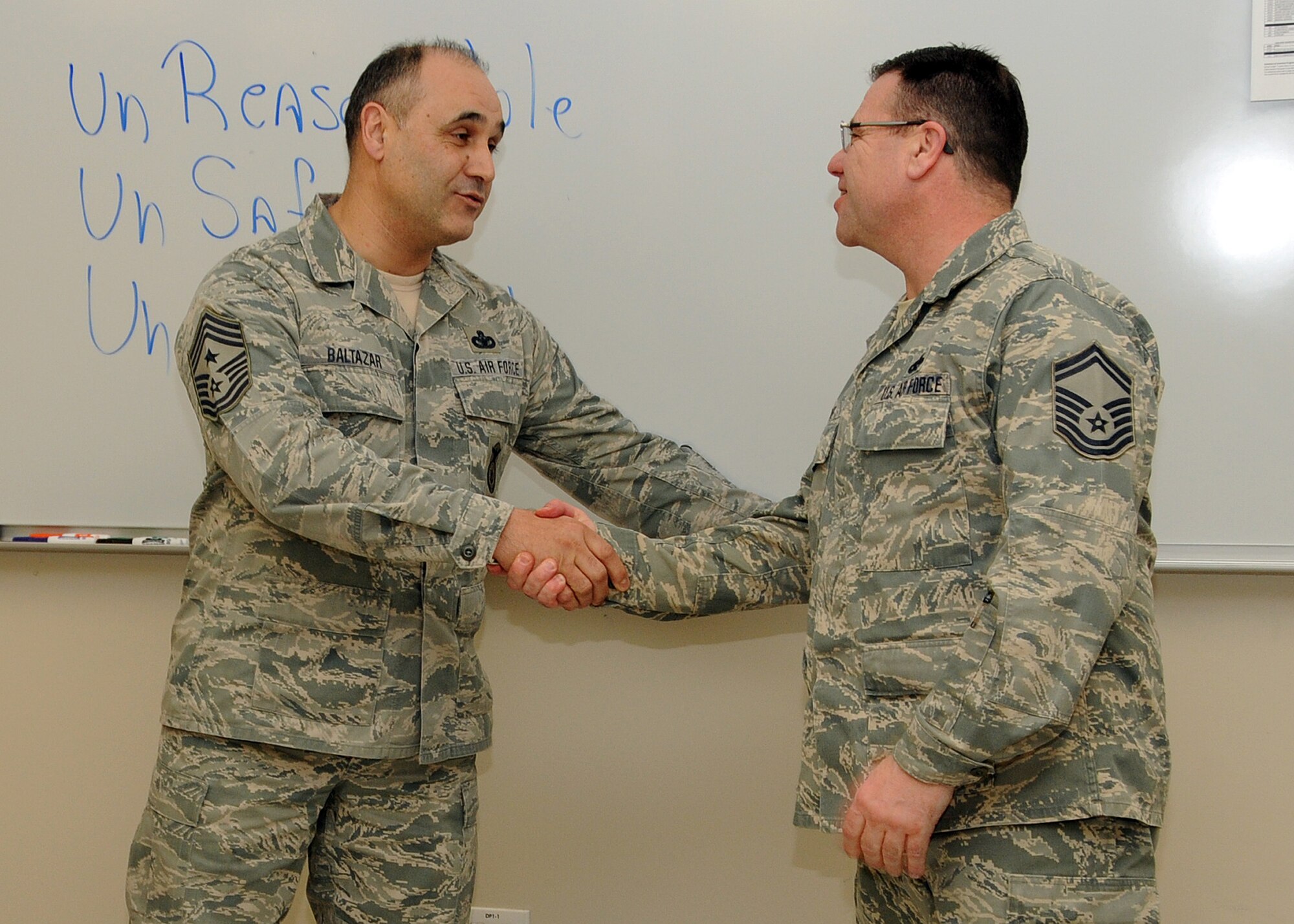 Command Chief Master Sergeant Jose Baltazar, Command Chief, 143d Airlift Wing, Rhode Island Air National Guard, presents Senior Master Sergeant Joseph Hart, Human Resource Advisor, 143d AW, with a challenge coin for his role in preparing for, executing and instructing at the inaugural Leadership Development Course held at Quonset Air National Guard Base, North Kingstown, Rhode Island on January 21, 2015. National Guard Photo by Master Sergeant Janeen Miller (RELEASED)