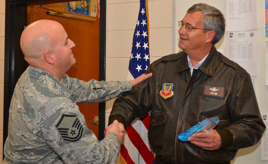 U.S. Air Force Master Sgt. Jose Padilla, noncommissioned officer in charge of recruiting for the 116th Air Control Wing, Georgia Air National Guard, congratulates U.S. Air Force retired, Lt. Col. Steve Atkins, on his earning the National Guard Bureau’s Community Influencer Award at Veteran’s High School, Kathleen, Ga., Feb. 12, 2015.  Atkins, a senior aerospace science JROTC instructor, was honored in front of his class for his outstanding Air National Guard recruiting and retention support.  (U.S. Air National Guard photo by Tech. Sgt. Regina Young/Released)