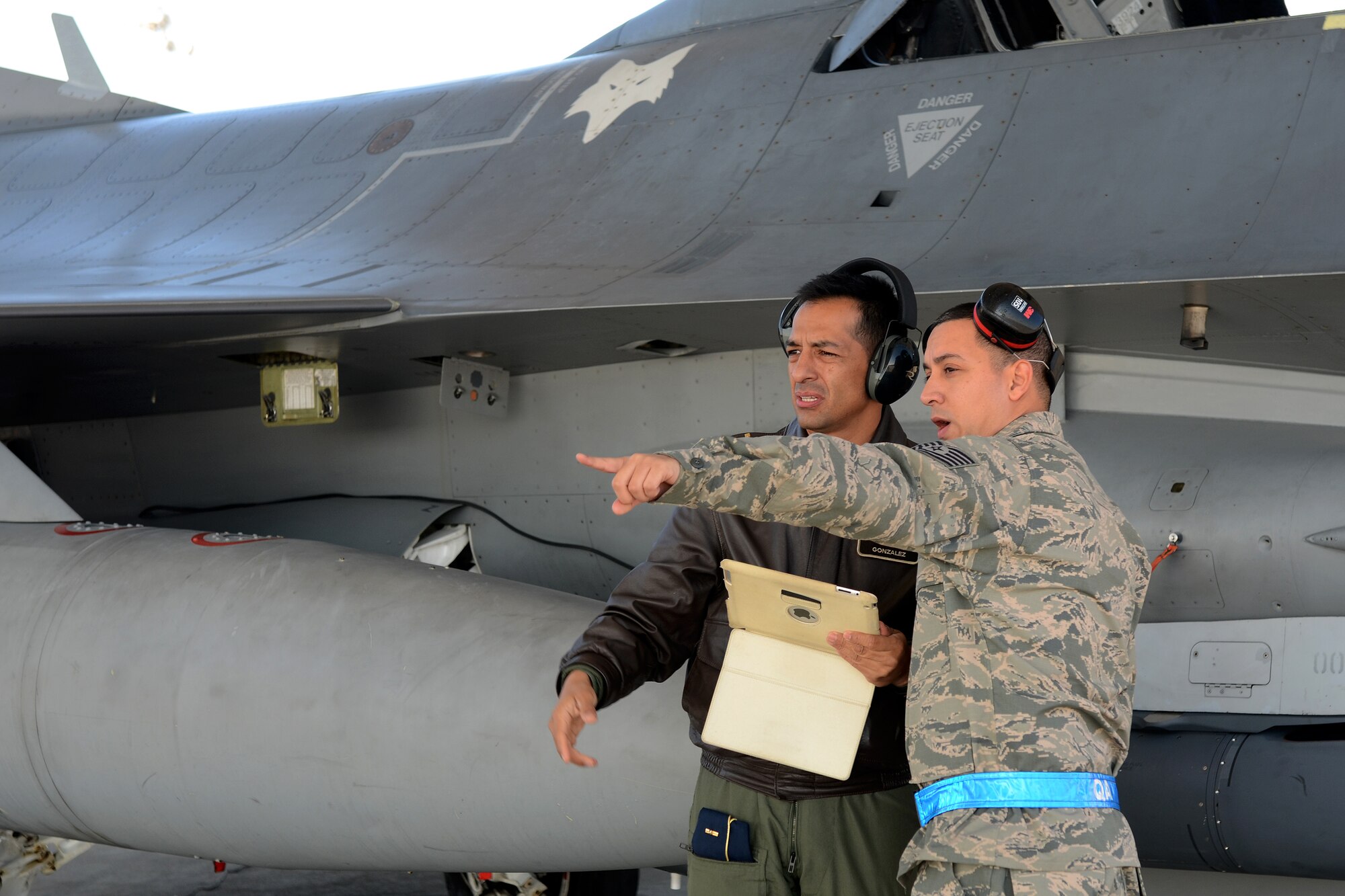 Maj. Juan Gonzalez (left), a Colombia Air Force maintenance officer, receives a flightline orientation from U.S. Air Force Tech. Sgt. Michael Hernandez, an F-16 crew chief with the 495th Fighter Group, Det 157 at McEntire Joint National Guard Base, S.C., during a visit to the base Feb. 20, 2015.  In addition, the Colombia Air Force commander, General Guillermo Leon Leon and six flight and maintenance officers are visiting the South Carolina Air National Guard as part of a Key Leader Engagement and Subject Matter Expert exchange sharing information on flying and maintenance operations at McEntire and fostering relationships between the militaries. The visit was the latest engagement for the State Partnership Program between South Carolina and the Republic of Colombia. (U.S. Air National Guard photo by Tech. Sgt. Caycee Watson/Released)