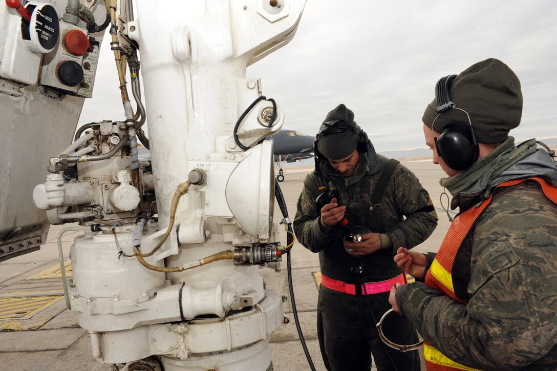 Airman 1st Class Gabriel Henry (left) and Airman 1st Class Rebecca Benton (right), 28th Aircraft Maintenance Squadron aerospace maintenance crew chiefs, repair a light on the landing gear of a B-1 bomber during Combat Hammer at Ellsworth Air Force Base, S.D., Feb. 12, 2015. Throughout the week, B-1 aircrews from the 37th Bomb Squadron took part in the exercise to test their ability to employ laser Joint Direct Attack Munitions against moving targets. (U.S. Air Force photo by Senior Airman Hailey R. Staker/Released)