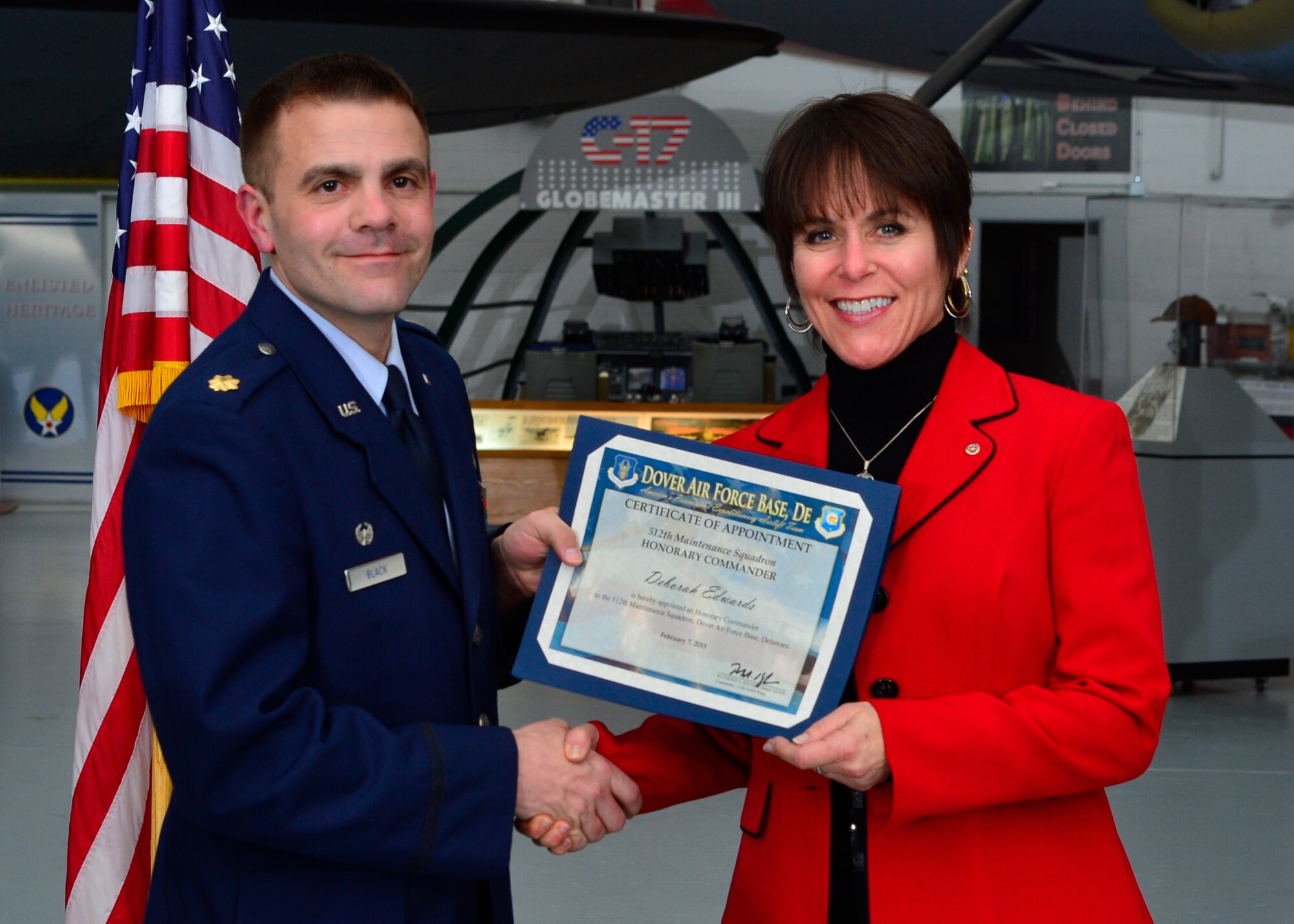 Maj. David Black, 512th Maintenance Squadron commander, presents a certificate of induction to Deborah Edwards, Central Delaware Chamber of Commerce director of membership, as part of the Team Dover Honorary Commander Induction Ceremony Feb. 7, 2015, at the Air Mobility Command Museum. The Honorary Commander Program began in 1992 at Dover Air Force Base, Del.,to foster relationships between civic and military leaders. (U.S. Air Force photo/Airman 1st Class William Johnson)
