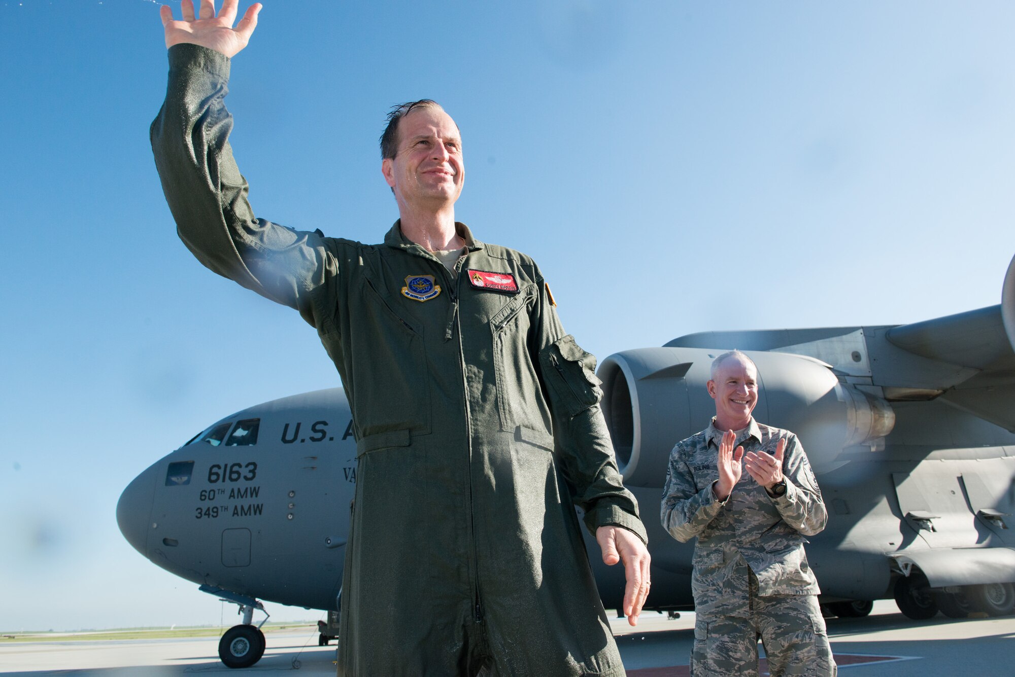 Col. Corey Martin, 60th Air Mobility Wing commander, received a warm, but wet welcome from his wife and children upon completing his "fini flight" at Travis AFB, Calif., Feb. 17, 2015. Martin has been the wing commander since August 2014, and will soon begin his new assignment in South Korea. (U.S. Air Force photo/Ken Wright)