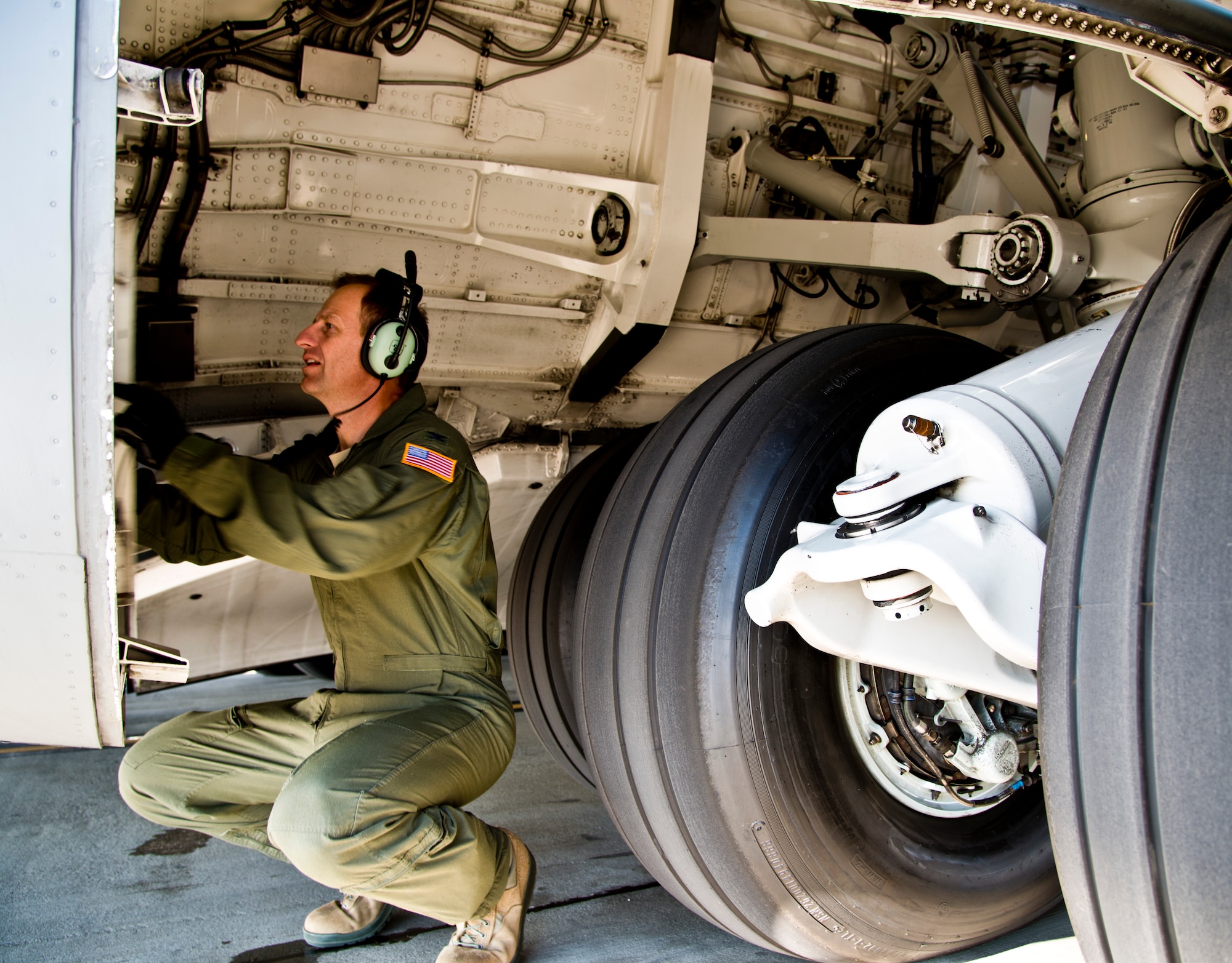 Col. Corey Martin, 60th Air Mobility Wing commander, inspects a C-17 Globemaster III landing gear area prior to his fini-flight Feb. 17, 2015. (U.S. Air Force photo by Senior Airman Nicole Leidholm)
