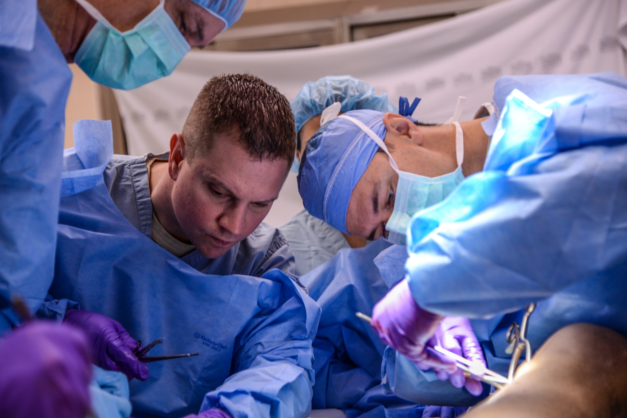 Maj. Scott Trexler, center, instructor, and Maj. Christopher Synder, right, general surgeon and student in the Emergency War Surgery Course, practice surgical procedures at the Wilford Hall Ambulatory Surgical Center on Joint Base San Antonio-Lackland, Texas, Feb. 11, 2015. The purpose of the Emergency War Surgery Course is to give deploying surgeons some of the basic trauma skills they will need when they deploy downrange. (U.S. Air Force photo/Staff Sgt. Michael Ellis)