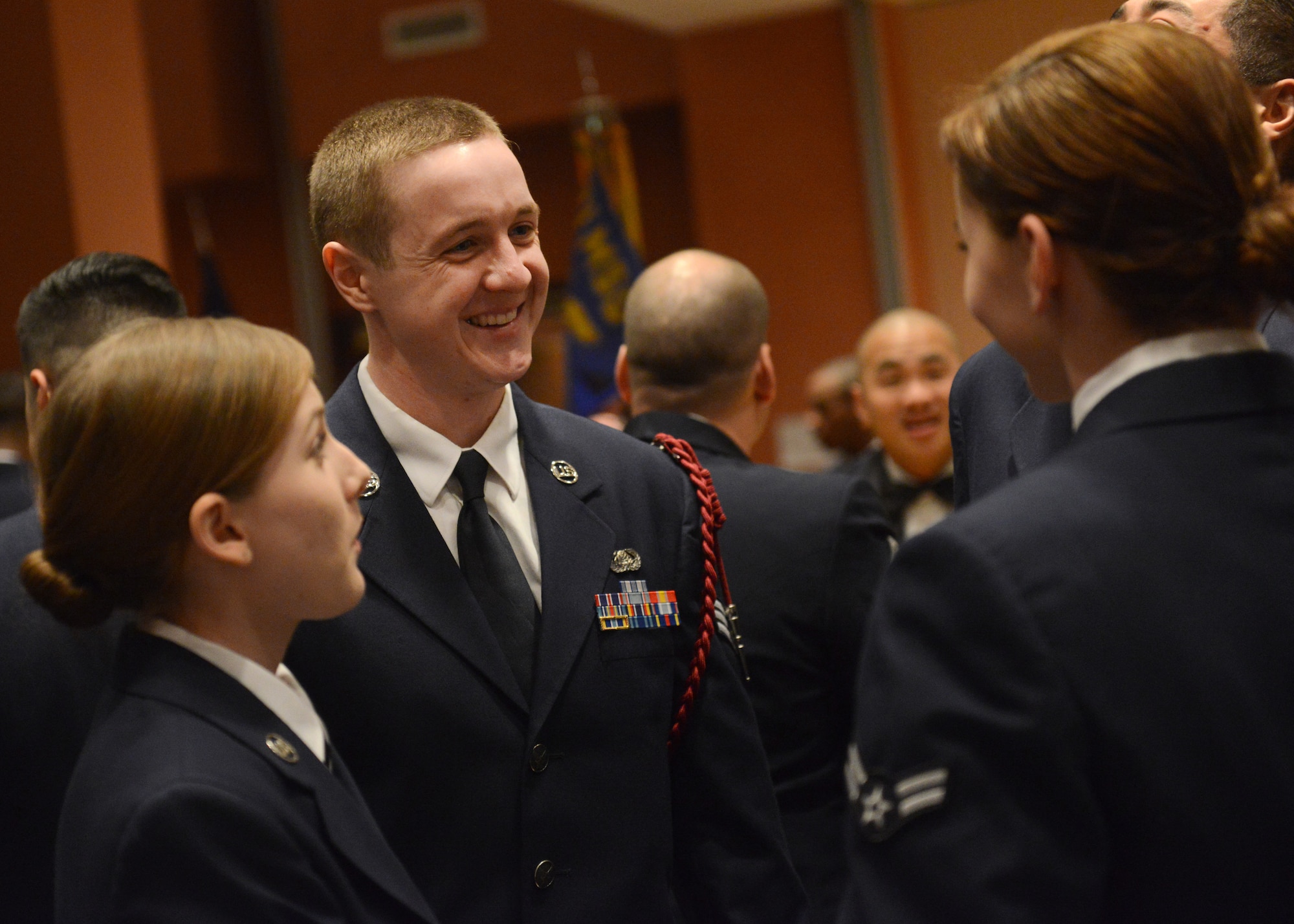U.S. Air Force Senior Airman Adam Clark, 31st Communications Squadron cyber transport systems journeyman, speaks with other Airmen before an Airman Leadership School graduation, Feb. 12, 2015, at Aviano Air Base, Italy.  ALS, a five-week course, helps develop front-line supervisors through several blocks of instruction. (U.S. Air Force photo by Staff Sgt. Evelyn Chavez/Released)